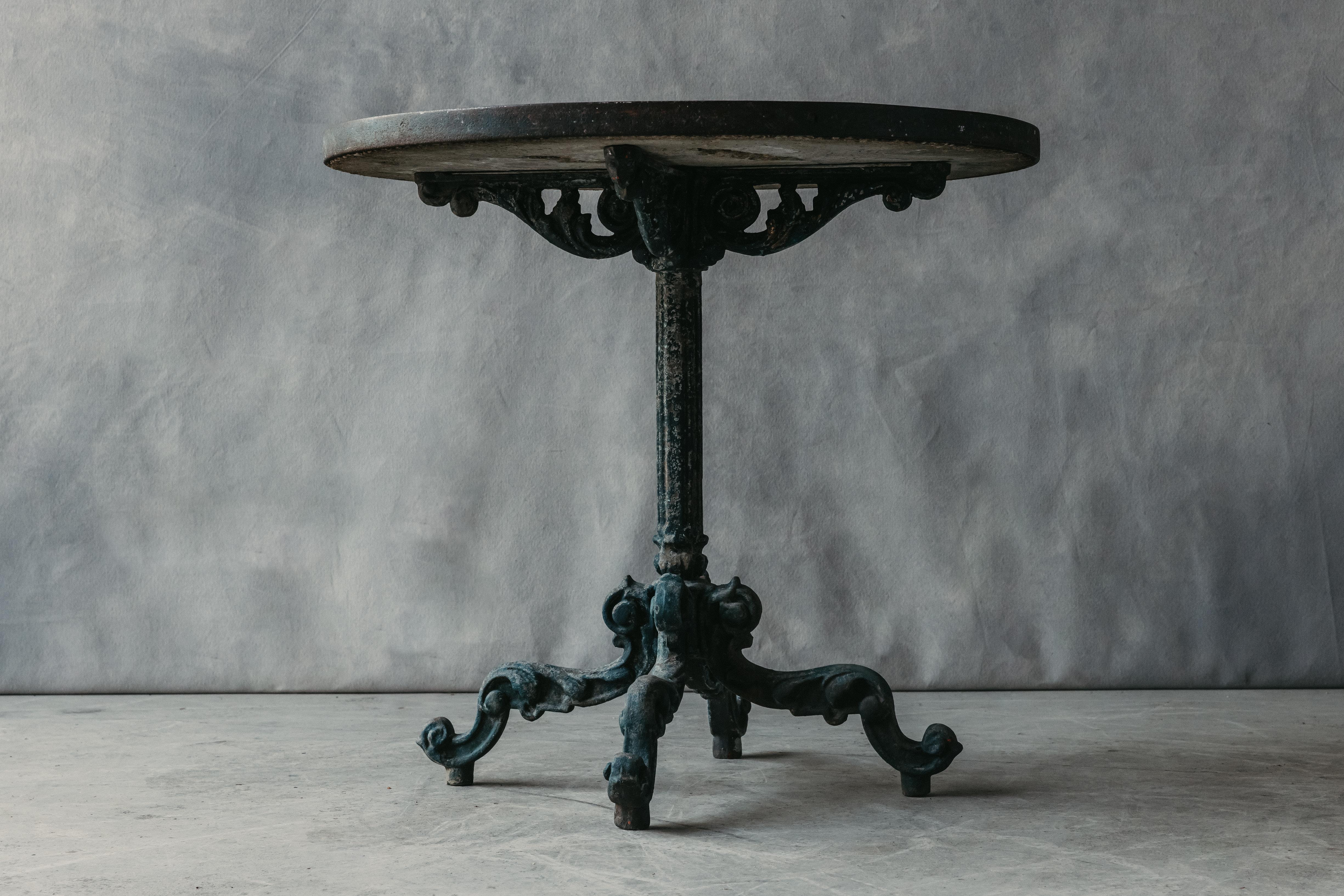 Early Cast Iron Garden Table From France, Circa 1930.  Solid cast iron base with fantastic detail and original color.  Concrete top with inlaid rock detail and mosaic style.