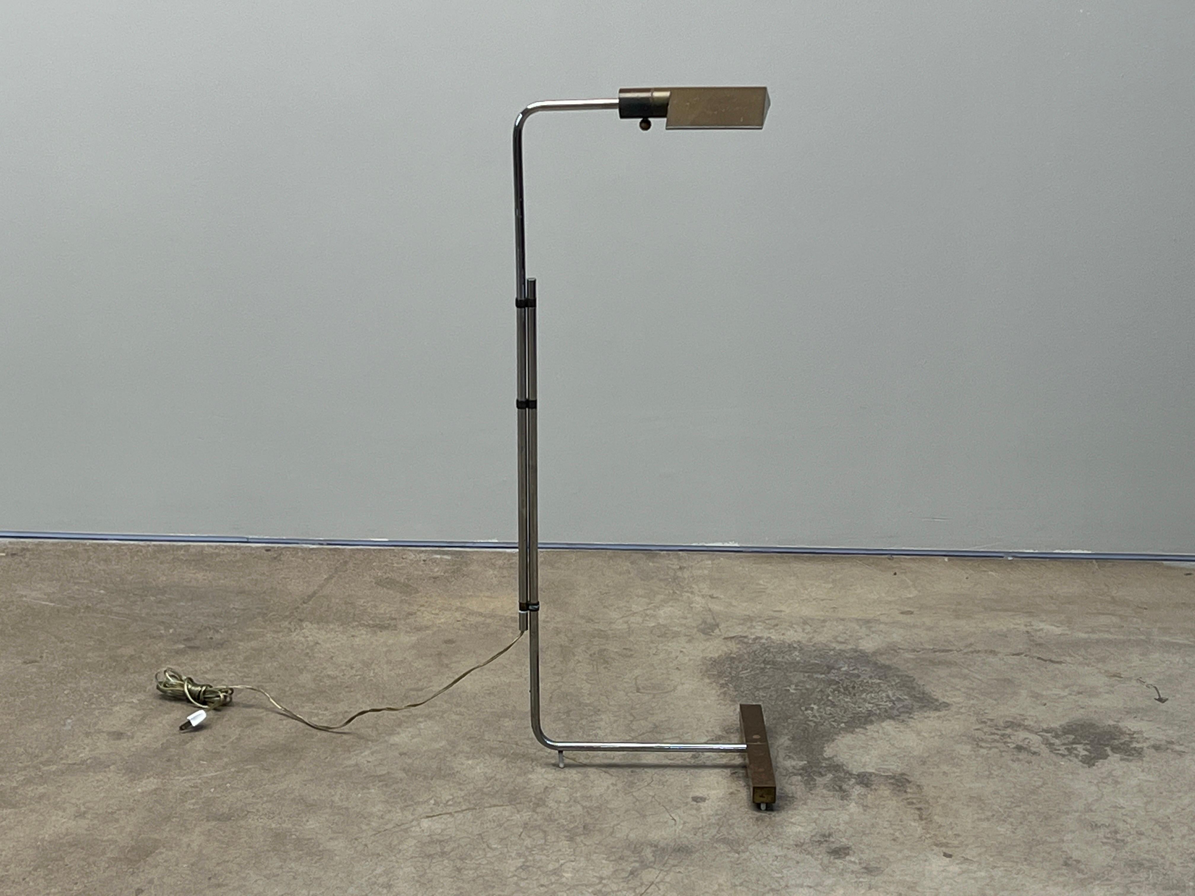 An early adjustable height floor lamp with rotating hood by Cedric Hartman. Chrome and brass with nice patina. Height 49