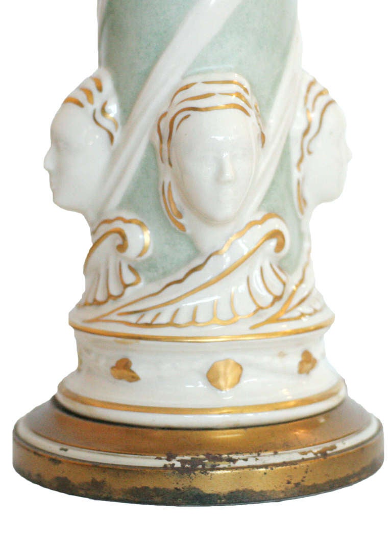 Ceramic Regency lamp featuring four female faces and painted gold accents by Rembrandt Light Company,

circa 1950.
