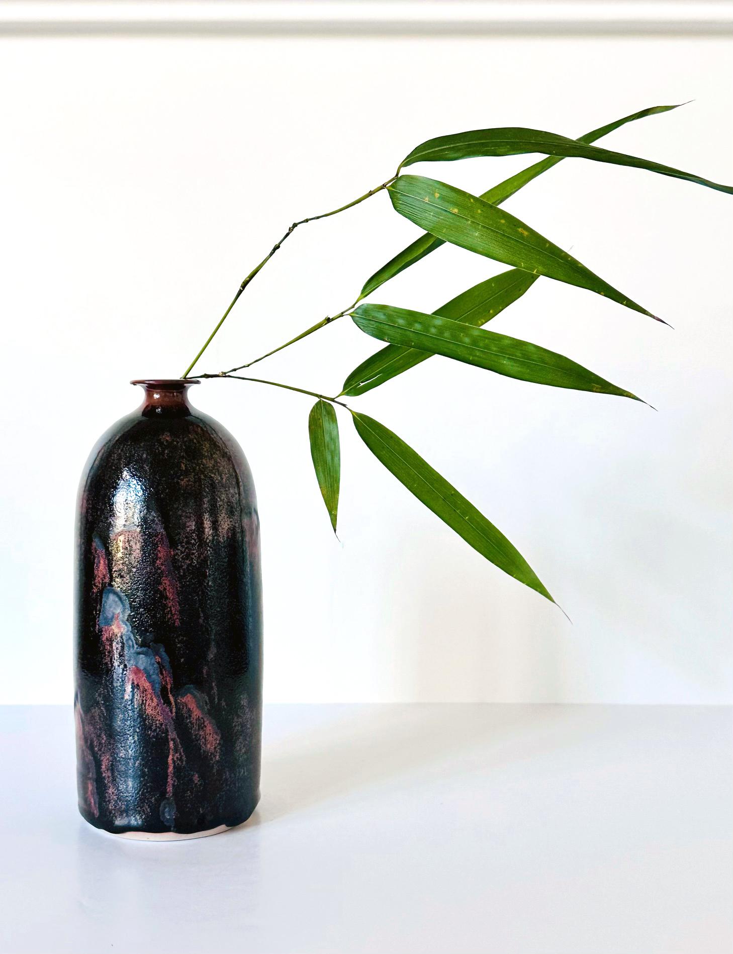 Un vaso in ceramica di forma cilindrica del ceramista Brother Thomas Bezanson (1929-2007). La silouette minimalista che si assottiglia verso l'alto e con una piccola bocca dal bordo piatto è sorprendente. L'aspetto straordinario di questo pezzo è la