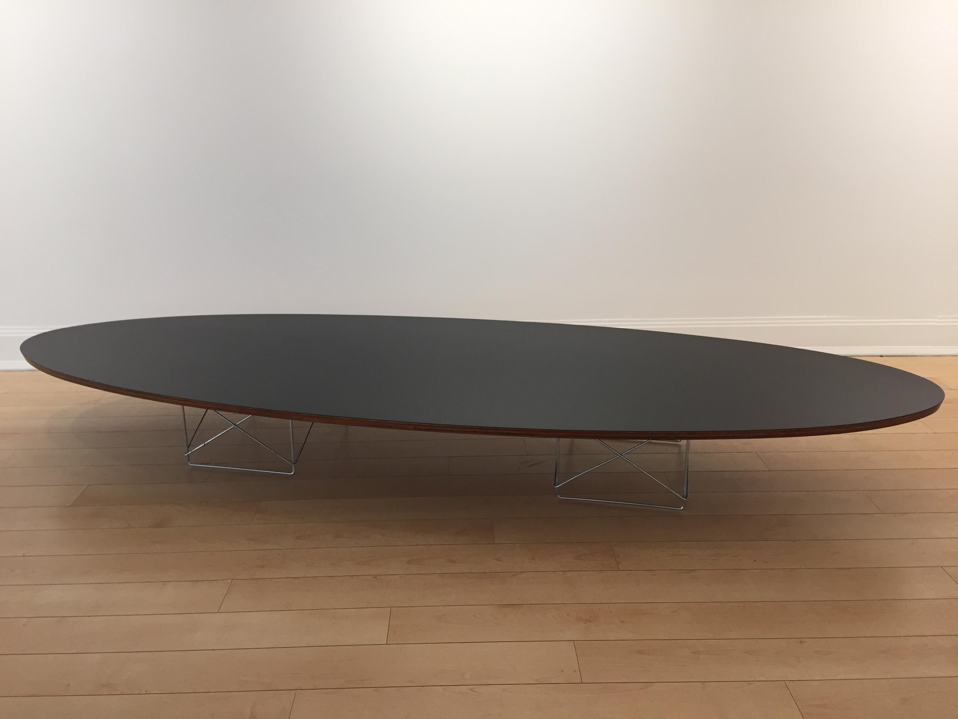 Früher ETR (elliptical Table rod base) Surfboard-Tisch von Charles und Ray Eames mit schwarzer Formica-Platte, Aluminium-Korbsockel und Kante in Schichtholz, Originalzustand mit frühem Metall-Rundschild. Charles Eames für Herman Miller.