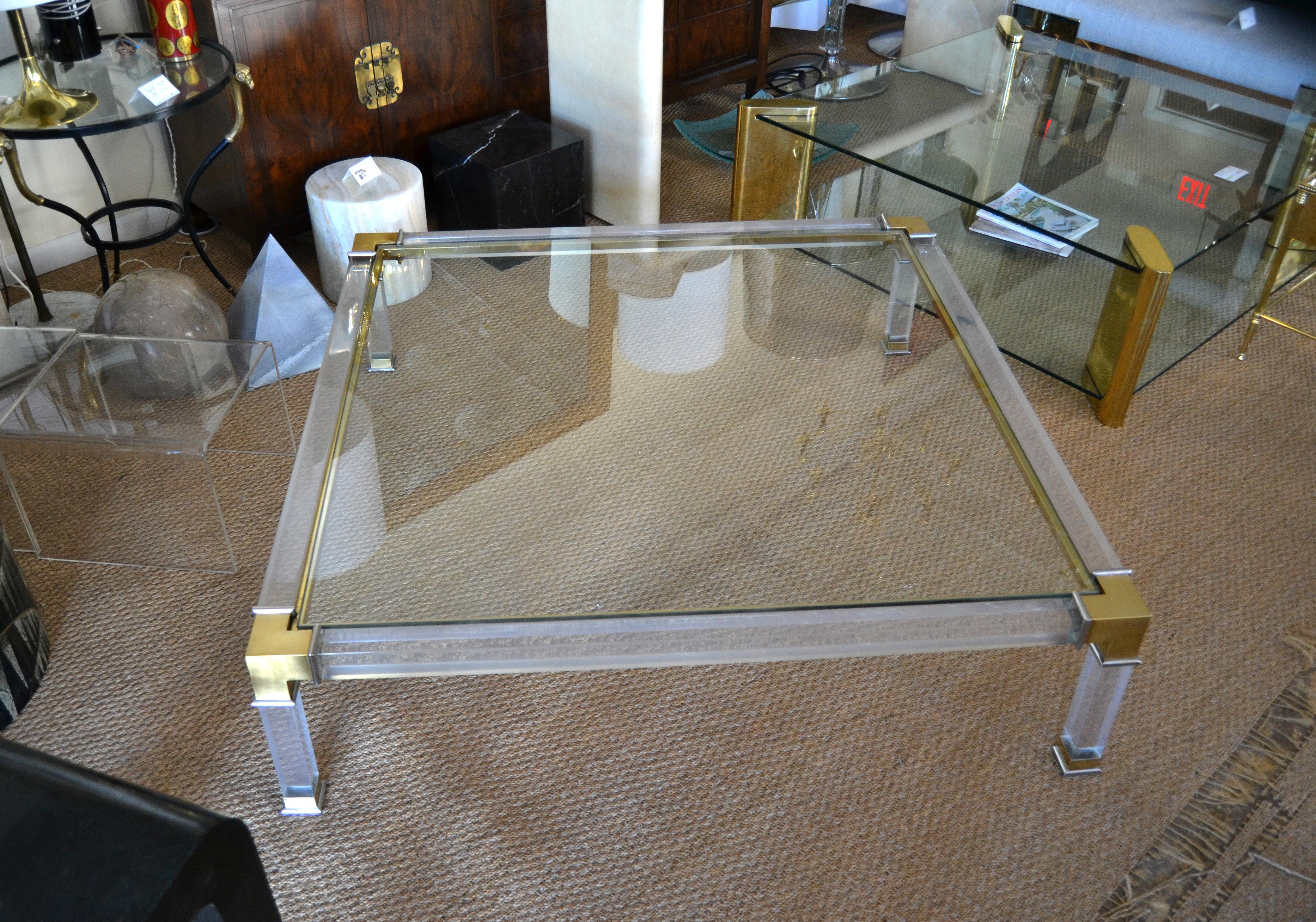 Early monumental lovely Hollywood Regency square acrylic, bronze glass coffee table with chrome details by Charles Hollis Jones.
Acrylic frames constructed with sturdy and durable bronze corners supported by chrome details.
Features a clear glass