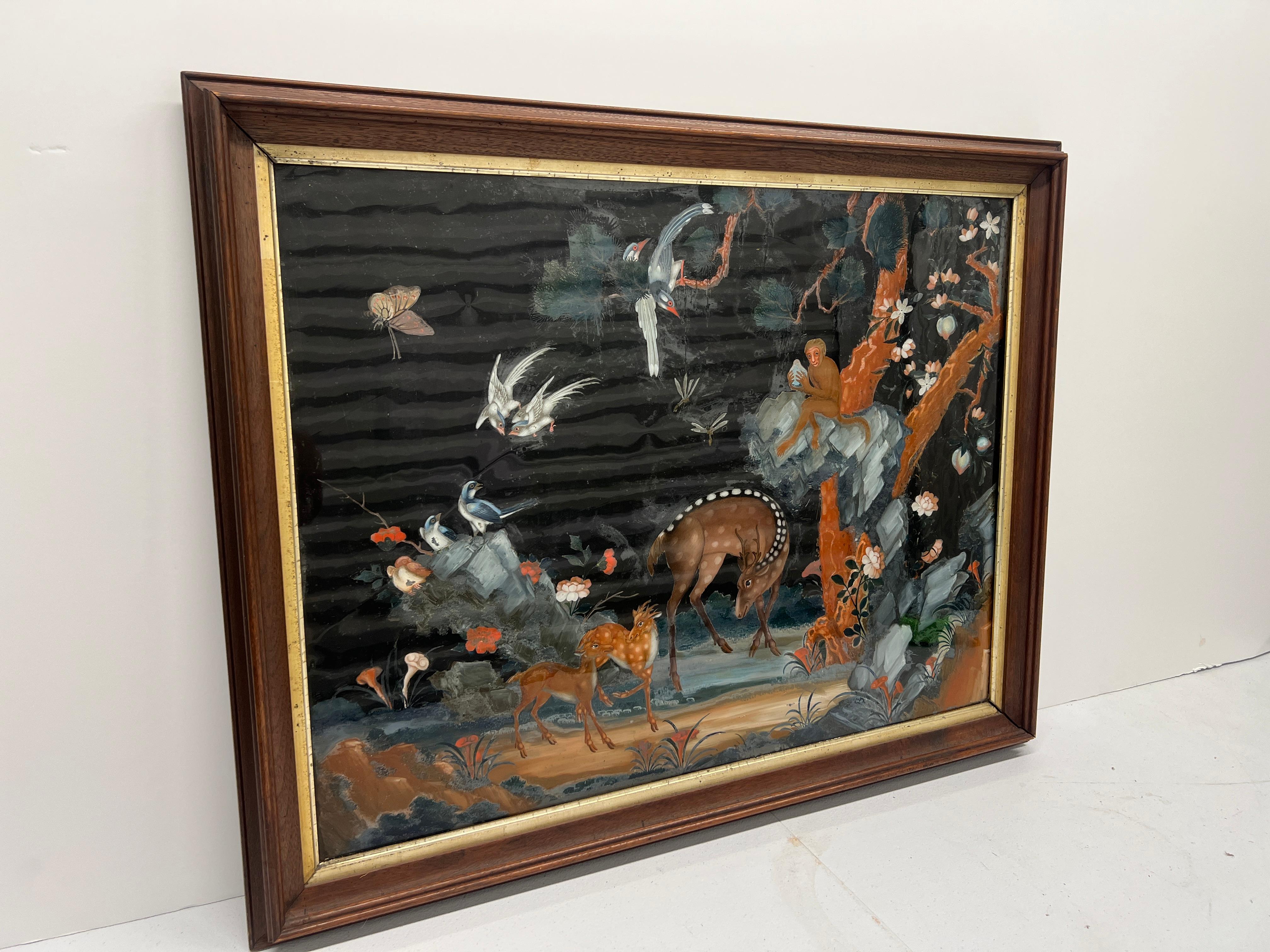 Cette exquise peinture en verre inversé d'exportation chinoise de la dynastie Qing (1644-1911), ancienne et très inhabituelle, représente magnifiquement une scène sereine de cerfs, de singes et d'autres animaux sauvages dans un cadre naturel