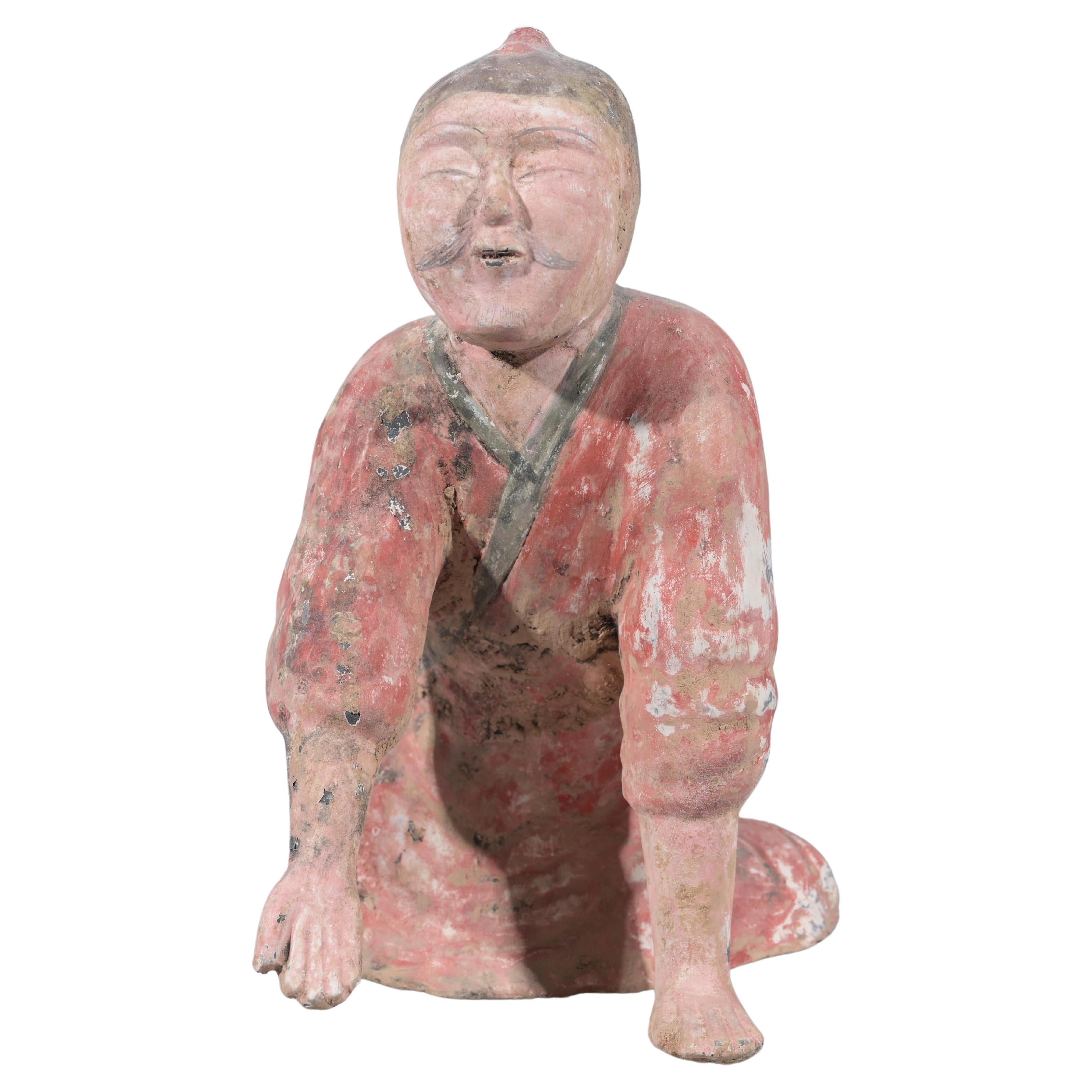 Chinesisch Tang-Stil Polychromed Keramik kniend Grab Figur. Die Keramik zeigt einen Mann in traditioneller asiatischer Kleidung, der kniet. Scharfe Gesichtszüge, einschließlich Augen, Brauen und Schnurrbart. Die Arme sind ausgestreckt.
