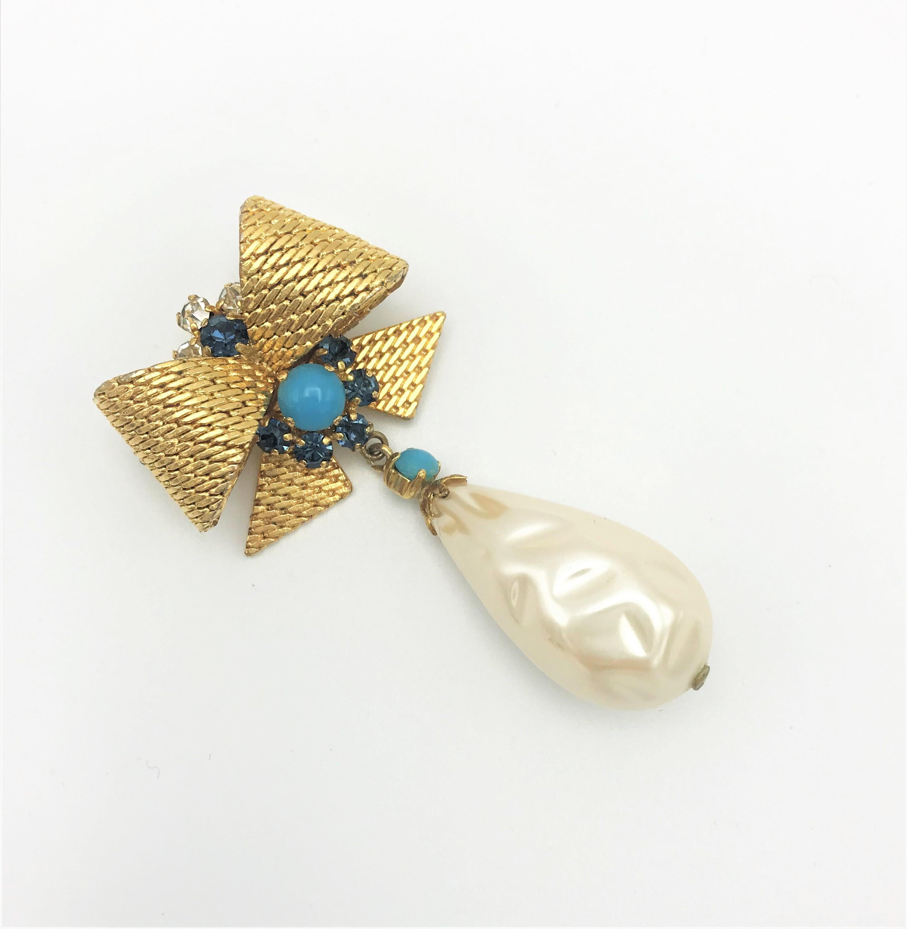 A very early ribbon brooch by Christian Dior with a large pendant drop of barock pearls. The brooch is signed 1967 Christian Dior Germany. Ch. Dior began designing fashion and jewelry in the 1950s. Before he had a Art Galerie in Franc. 
Above the