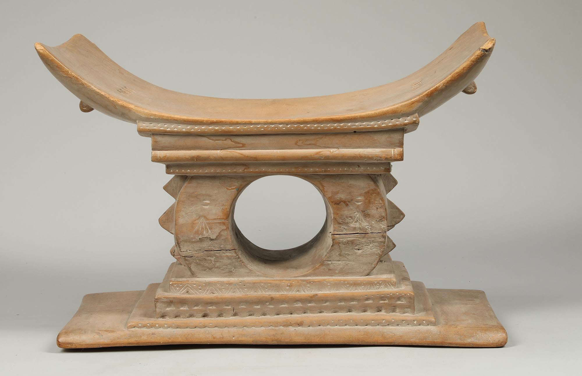 A well-loved traditional stool or seat from the Akan people of Ghana.  The supports for Akan stools take many forms, they can be purely geometric or architectural with simple posts and columns, or, as in this case, a open circular form supporting