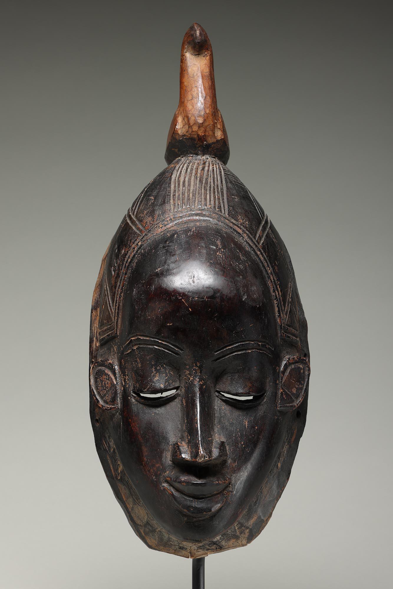 Antigua Máscara de Madera Negra Bailada de los Pueblos Guro de Costa de Marfil Pájaro en la parte superior. Máscara finamente tallada con ojos abiertos, nariz puntiaguda y boca ligeramente sonriente.  

Está en buen estado, adecuado a su edad, uso y