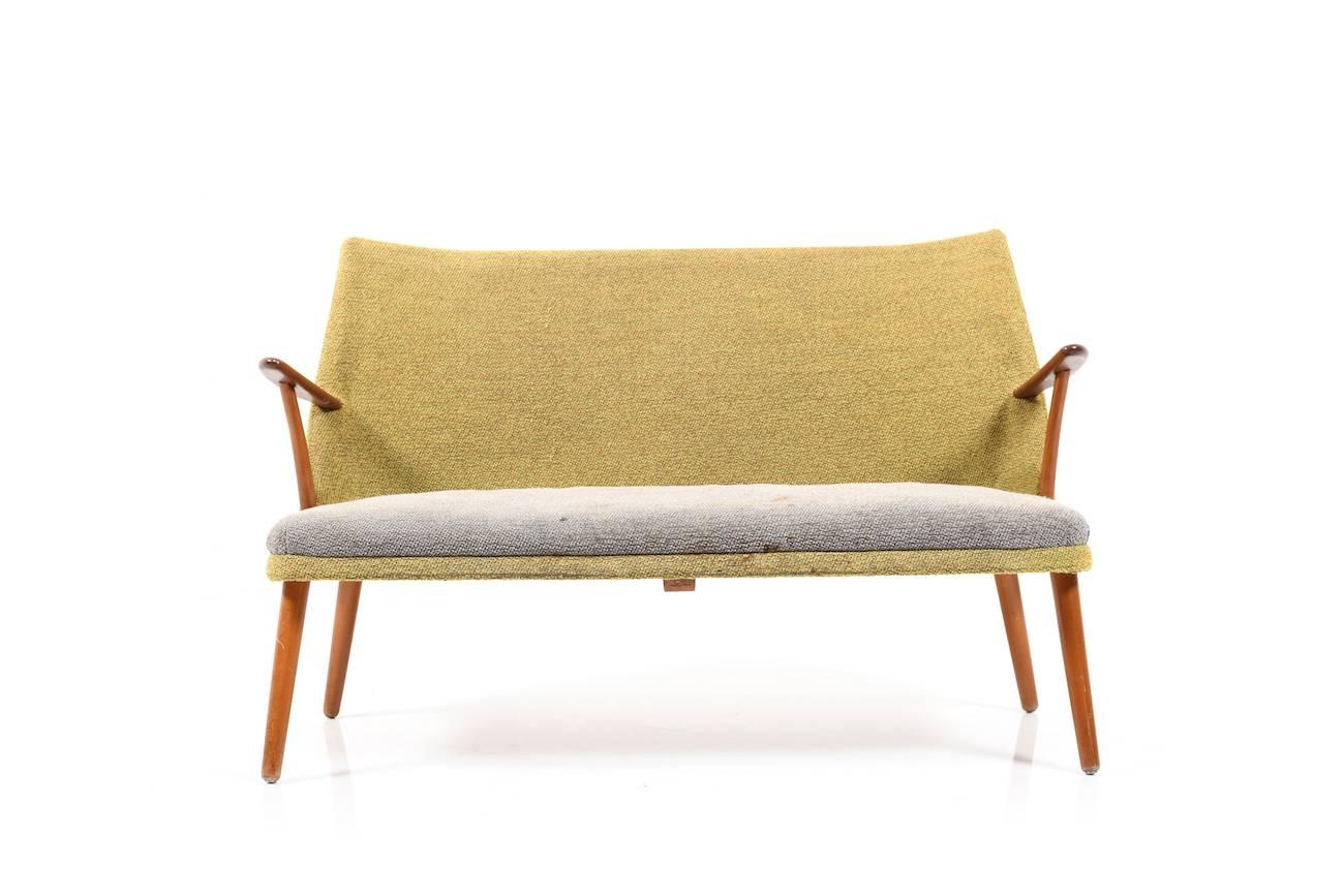 Early 1950s two-seat sofa. Upholstered in original green and grey fabric. Legs and armrests in teak and beechwood, early production, 1950s.