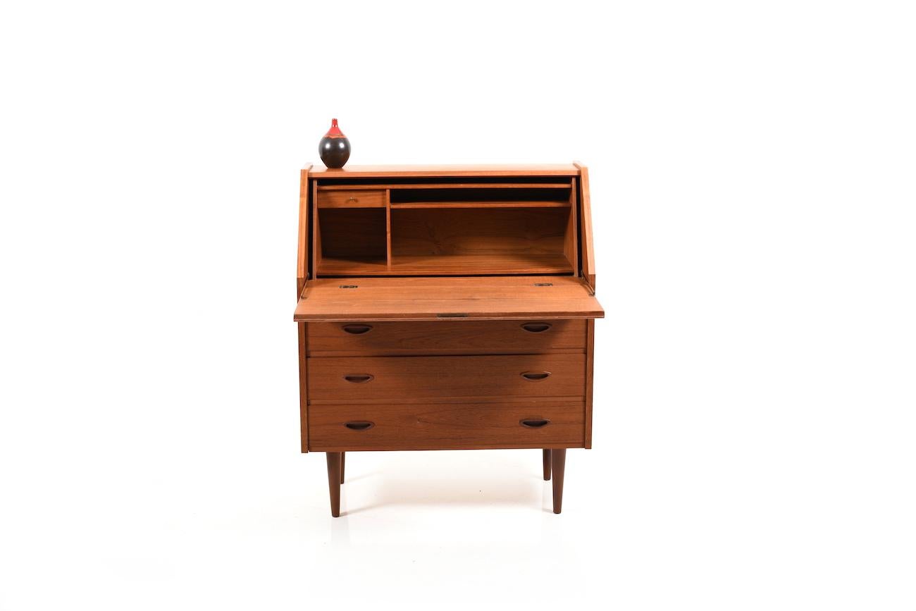 Early 1950s Danish secretary in teak. Front with three big drawers and a writing flap. Behind the writing flap are open storage compartments and a small drawer.