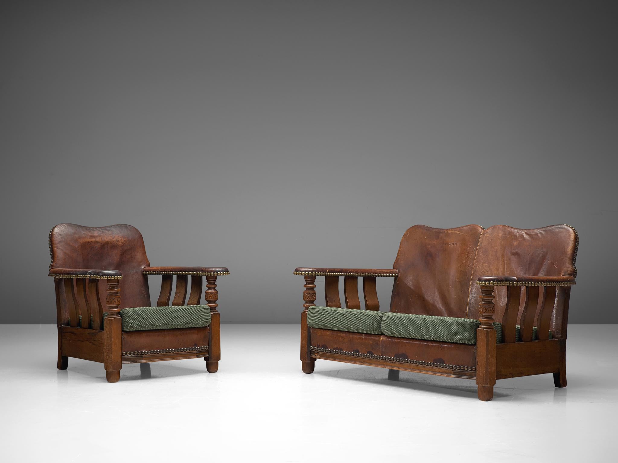 Settee sofa and lounge chair, wood, leather and fabric, Denmark, 1920s.

Exceptional example of early Danish design are this settee and lounge chair with robust, bulky aesthetics. The frames of these pieces are made of wood. The back and armrests