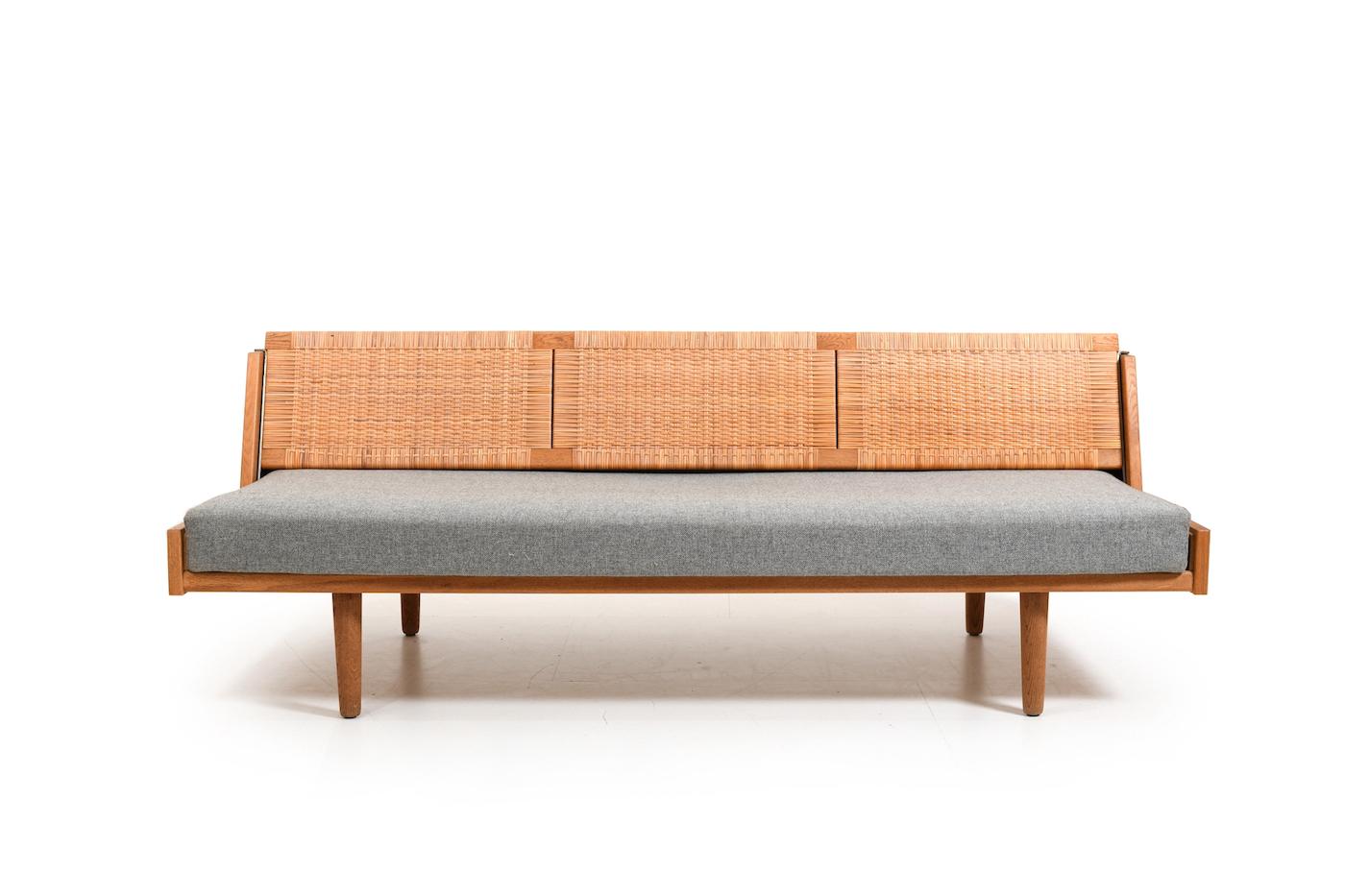 Daybed GE-258 in oak by Hans J. Wegner for Getama Denmark 1954. Backrest in wicker cane. Original mattress with grey fabric. Early production 1950s. with beatiful patina and round legs.