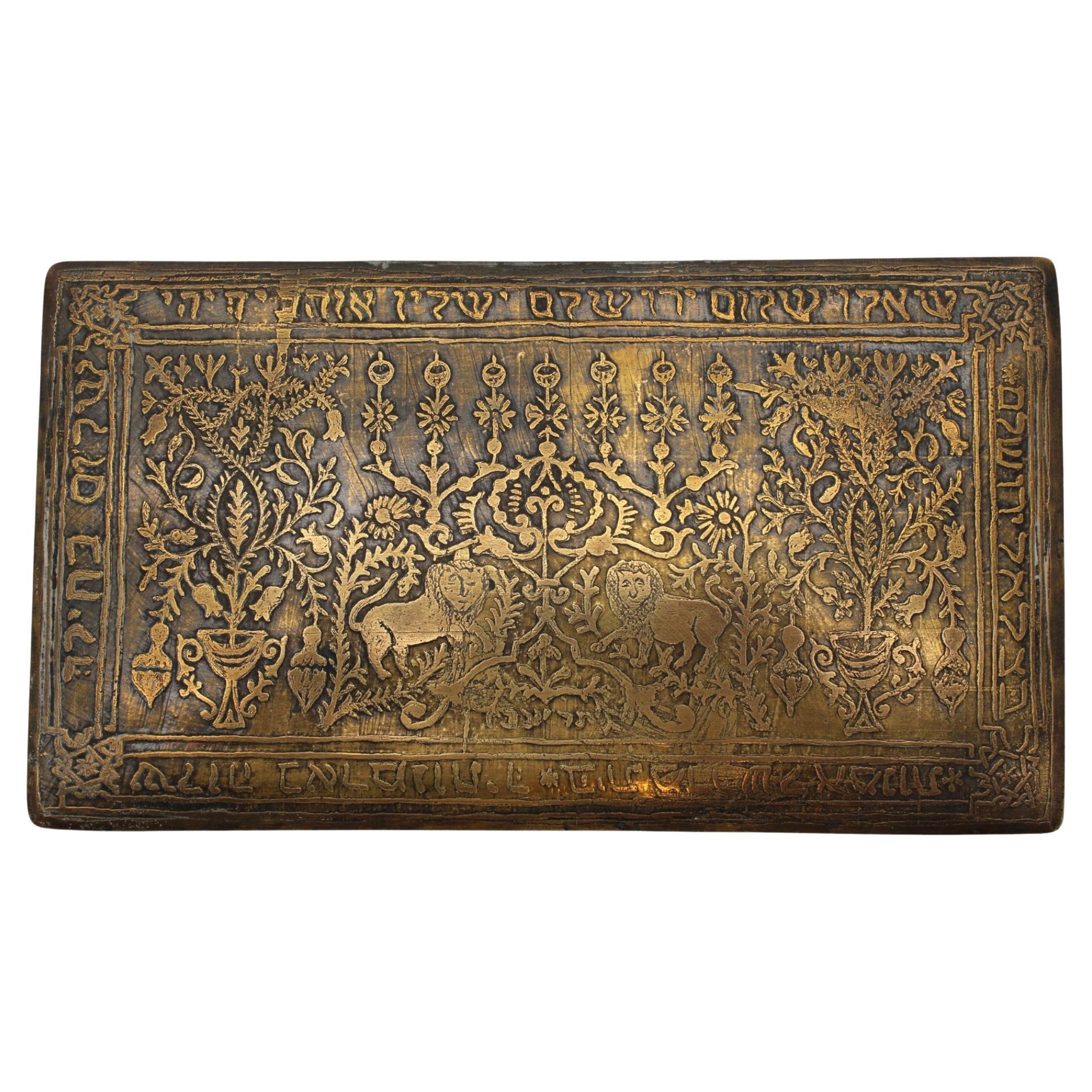 Magnifico esempio di artigianato Bezalel, questa scatola decorativa rettangolare, realizzata a Gerusalemme nel 1912, incarna gli ideali artistici e lo spirito nazionale della Scuola Bezalel durante i suoi anni formativi. Realizzata in ottone con