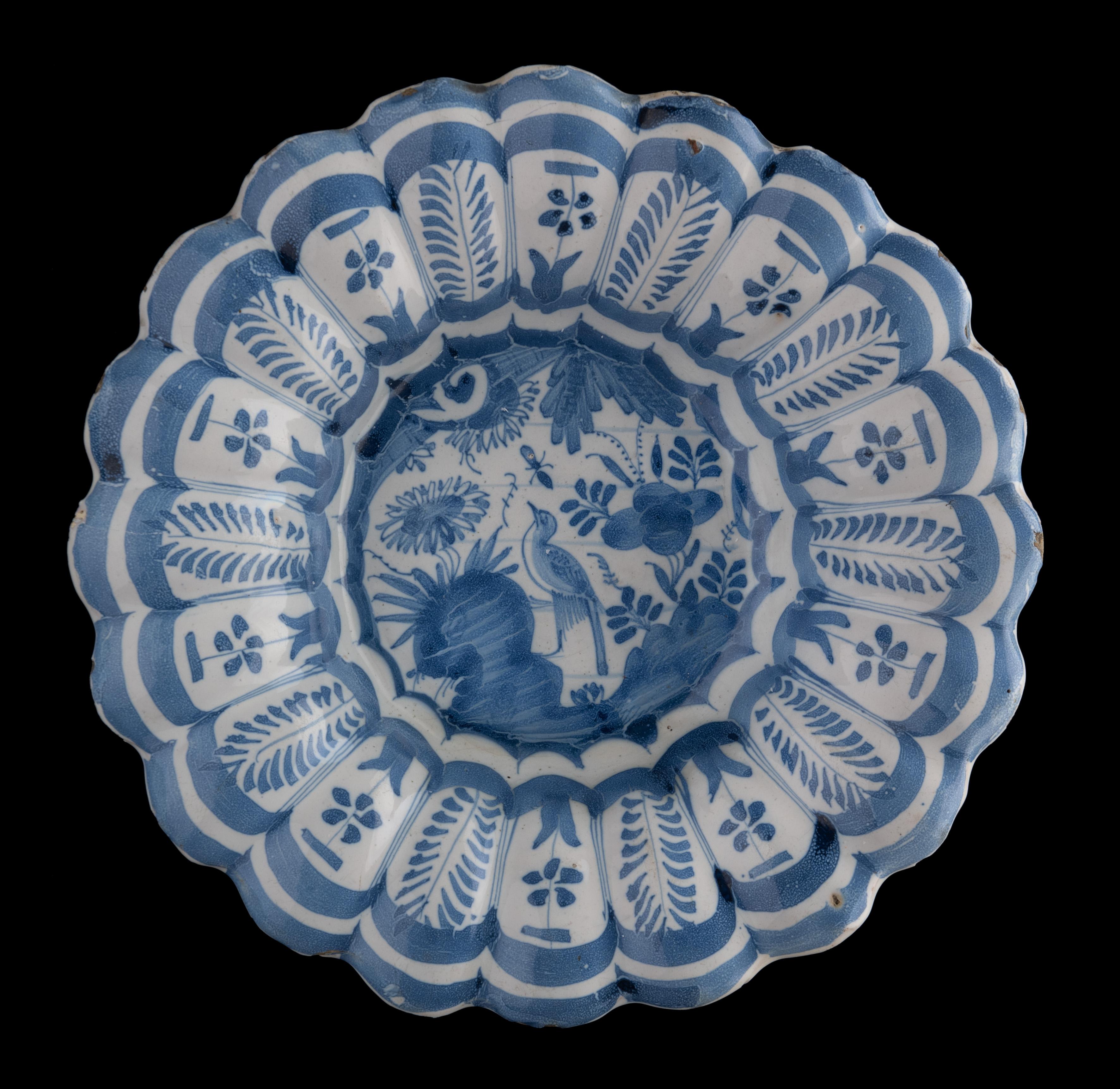 Blaue und weiße Chinoiserie-Schale mit Lappen
Die Niederlande, 1630-1650

Die blau-weiß gelappte Schale besteht aus zwanzig kleinen Lappen und ist in der Mitte mit einem floralen Chinoiserie-Dekor bemalt, das einen Vogel auf einem Felsen zwischen