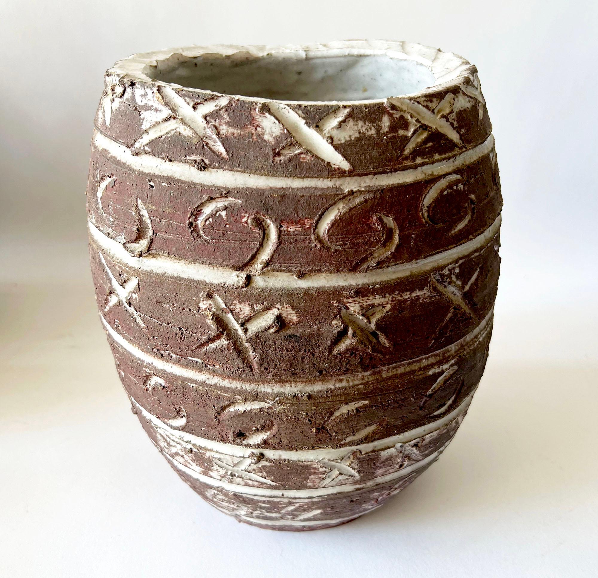 Rare, ovoid stoneware vase featuring carved X's and O's design, created by Doyle Lane of Los Angeles, California. Piece measures 9.5