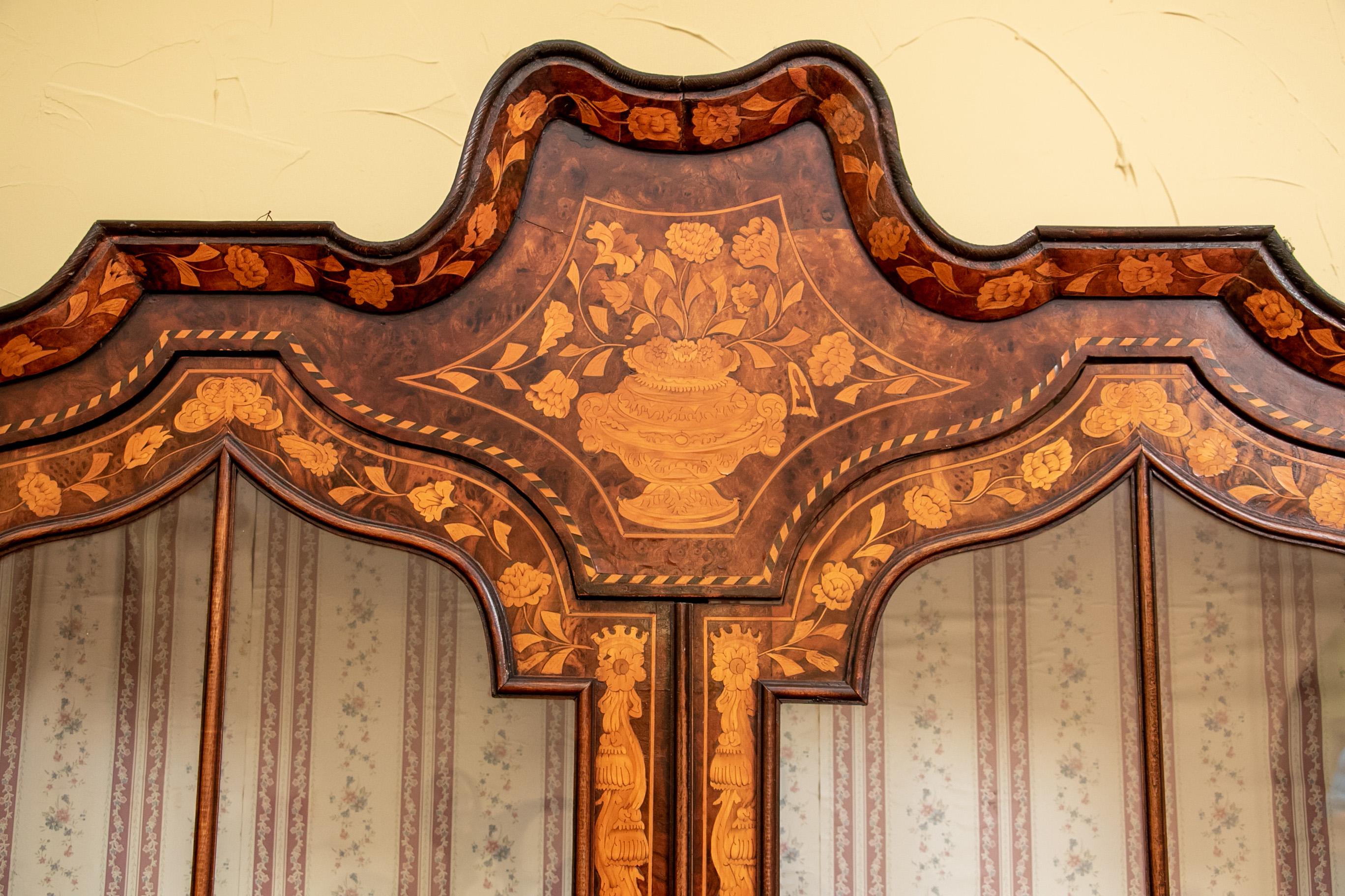 Wiederherstellung erforderlich. Niederländisches Intarsienkabinett, große eckige Form mit geformtem Gesims mit einem floralen Korbintarsienpaneel über doppelt verglasten Türen in der Mitte (ein Wappenschild, aber der Schlüssel fehlt), flankiert von