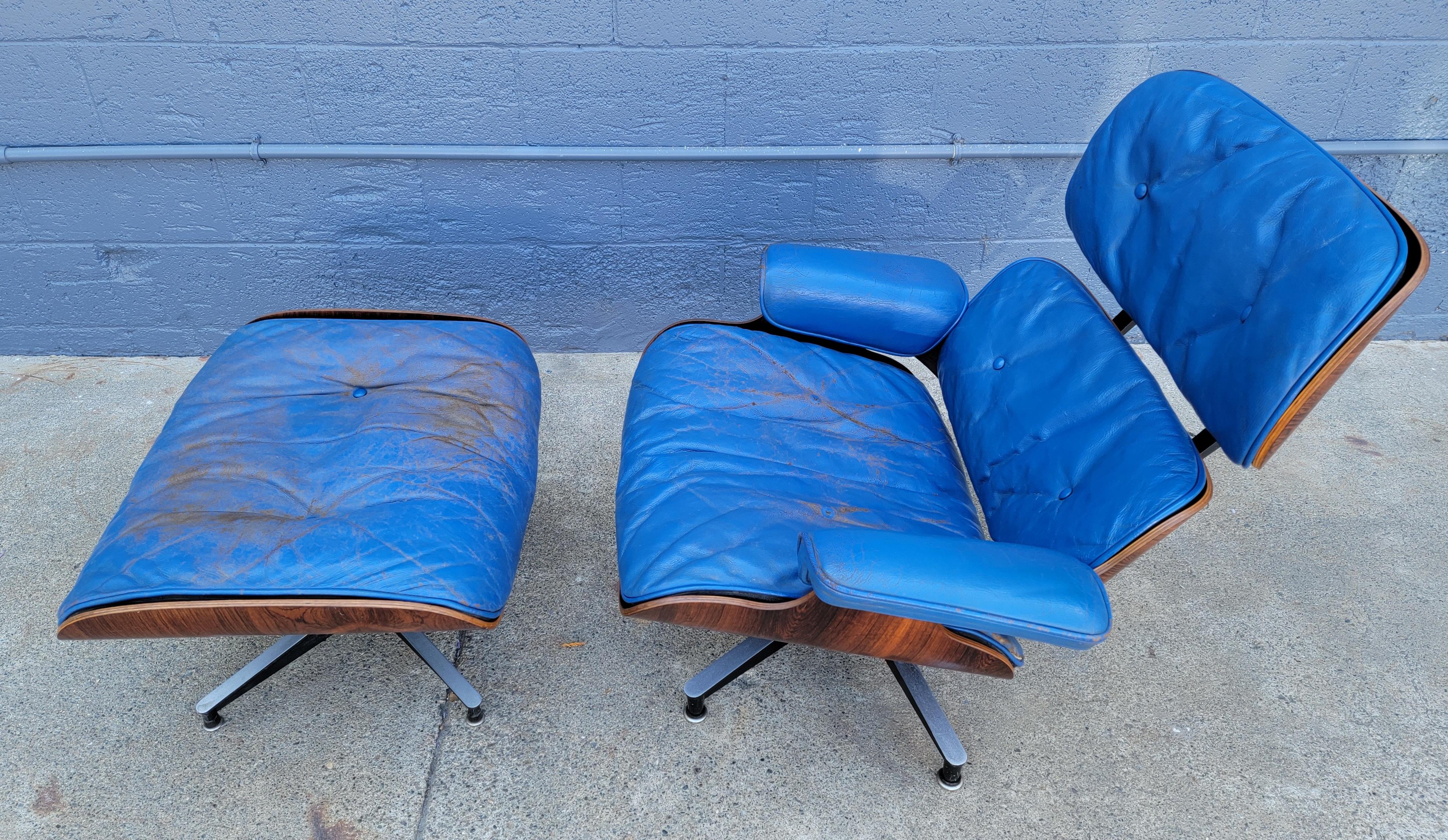 Here is a very unusual, early example of the iconic Charles & Ray Eames 670/671 Lounge chair & ottoman. Upholstered in original blue leather. Rosewood frame with down filled cushions. Original push on rubber boot glides. Three screws to armrests.