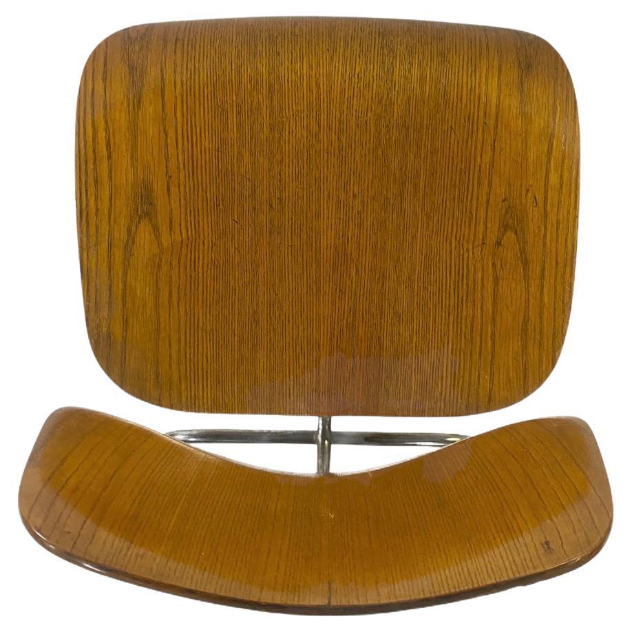 Early Eames DCM manufactured by Evans products, dating to 1946/1947. Original label remains under seat panel. In good condition given the age, with minor wear and losses. Absolutely amazing patina and character. This chair is a survivor and a must