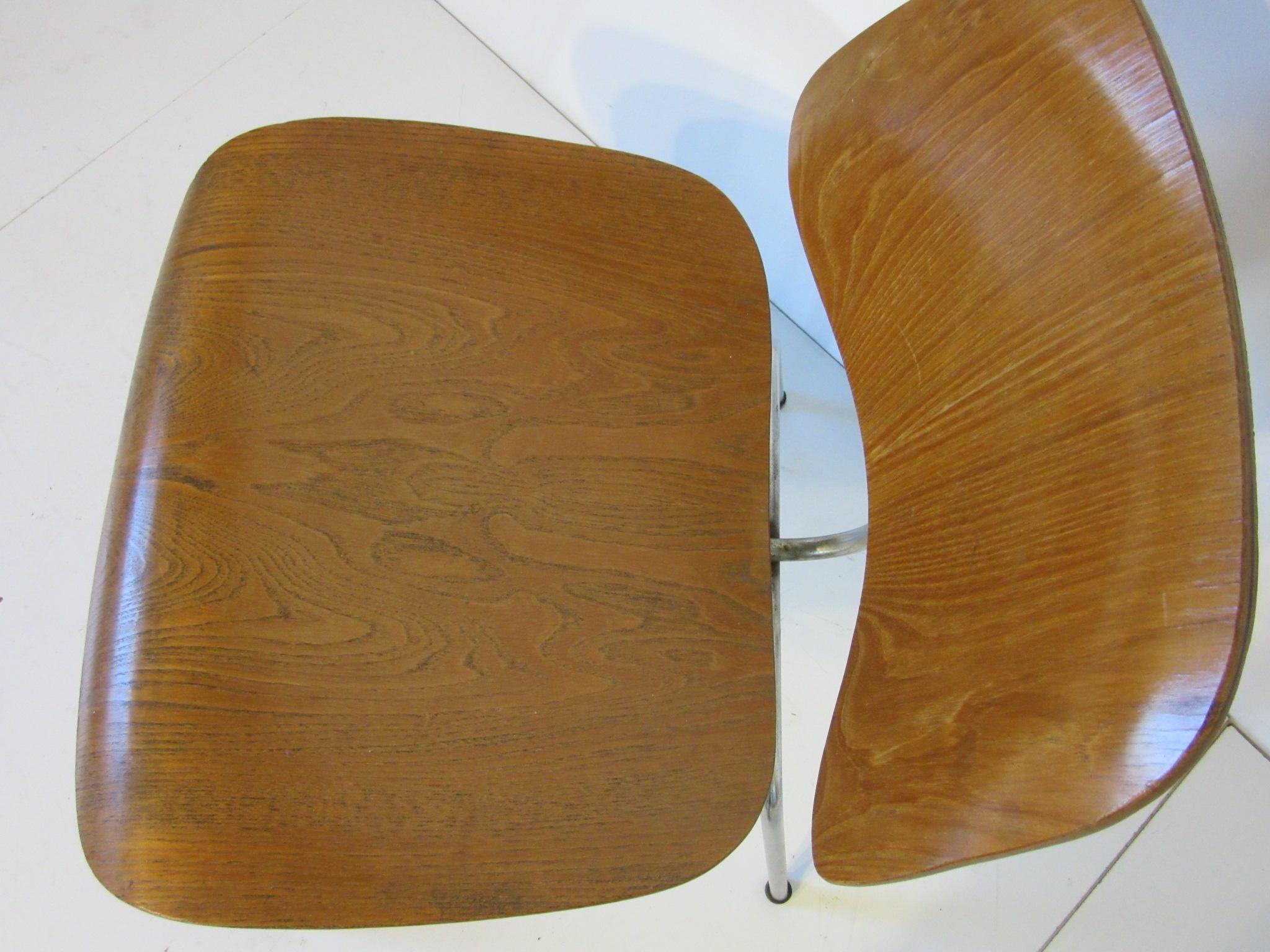 An early production oak bent plywood side chair with plated frame, domed feet and underside clamp styled base construction. Retains factory ink stamp date to the bottom 12- 1951 manufactured by the Herman Miller Furniture Company.