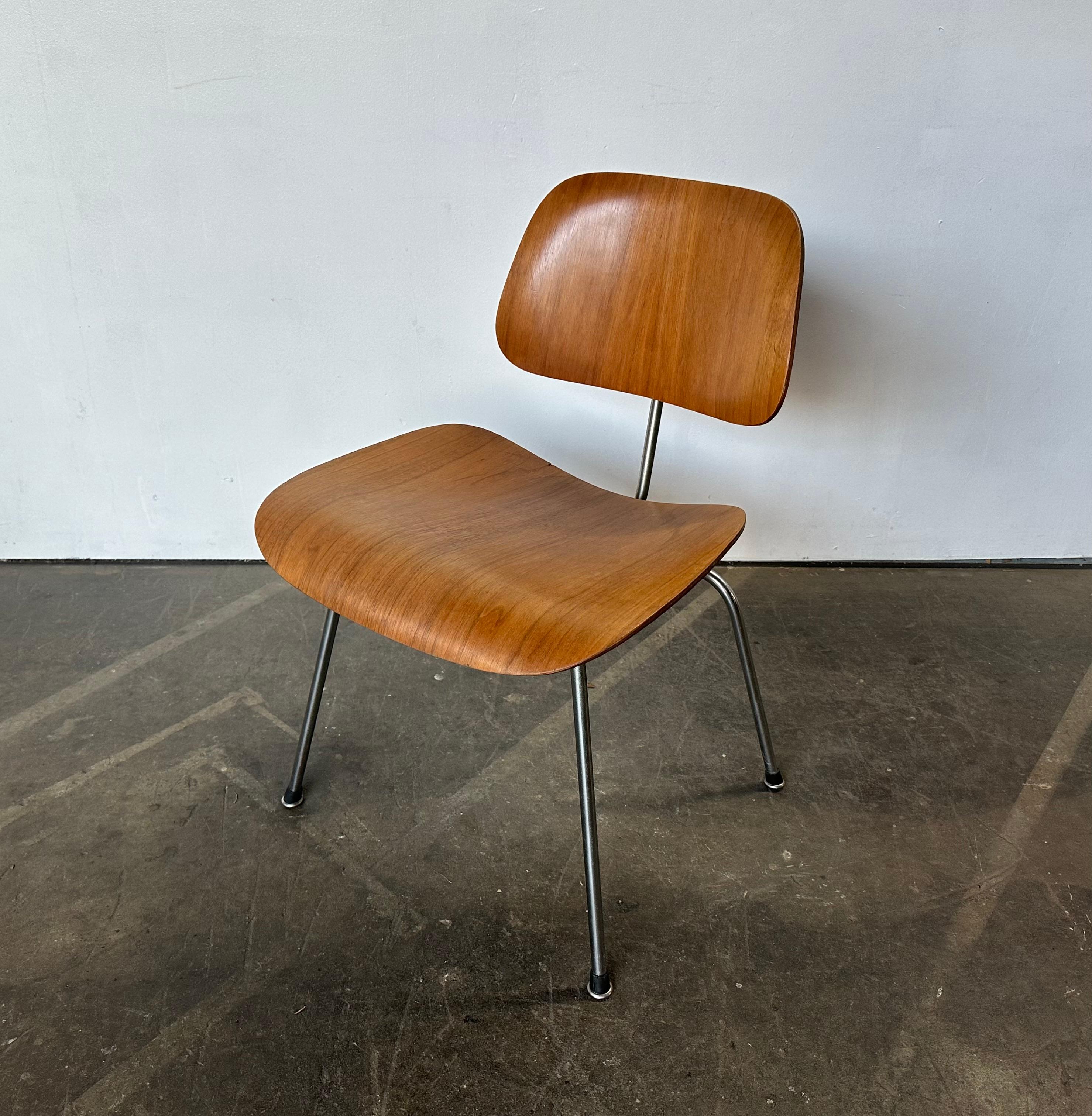 Gorgeous early Herman Miller edition Eames DCM chair. Molded seat and back with walnut finishes. Dates to the 1950s, with solid steel rod frame, with original plating. Metal in good condition with gorgeous age appropriate patina. All glides and