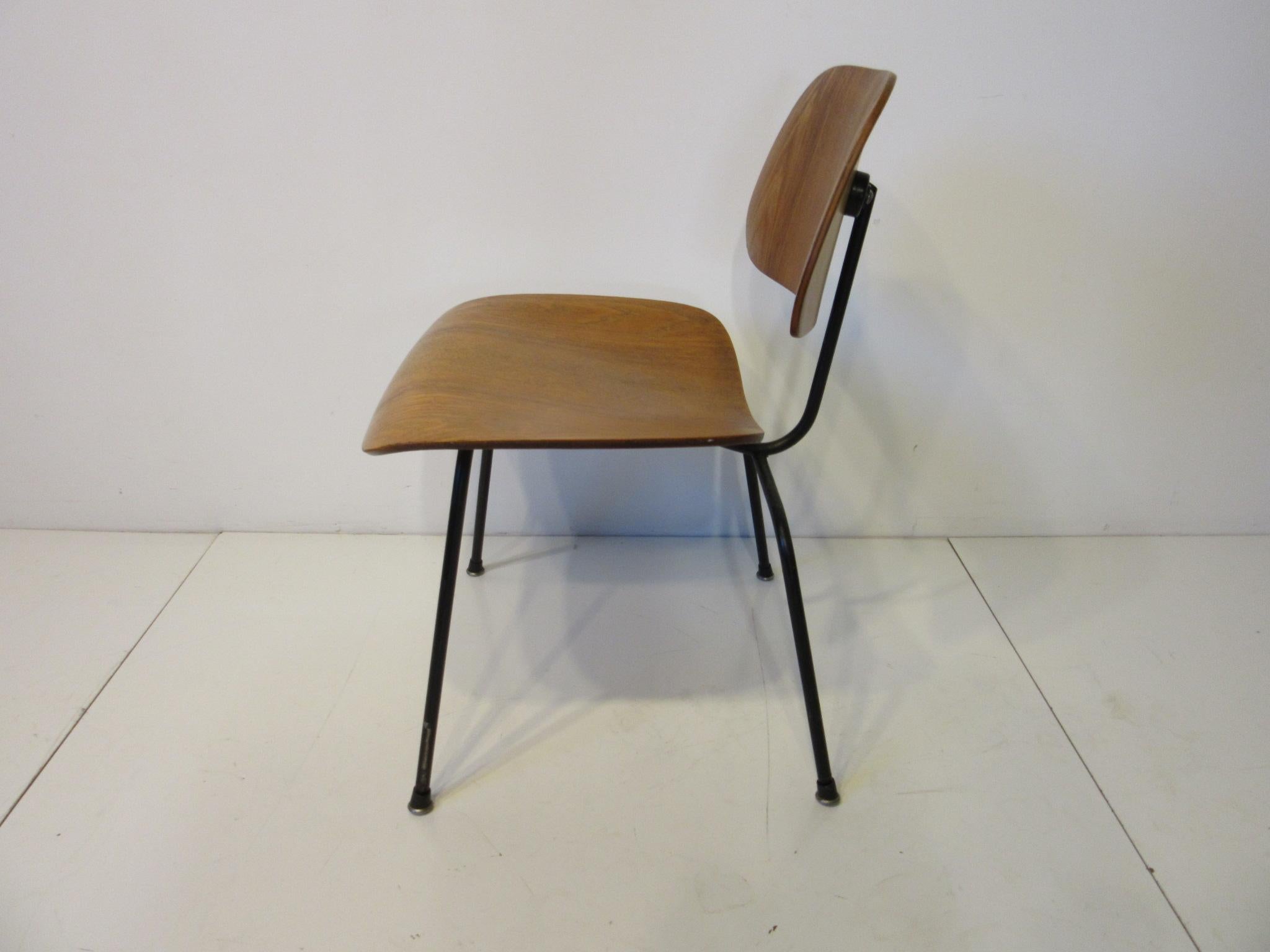 An early 1950s production molded wonderfully grained oakwood ply side chair with factory black metal frame, early patient and foil manufactures label and rubber metal boot styled feet. Purchased from the original owners made by the Herman Miller