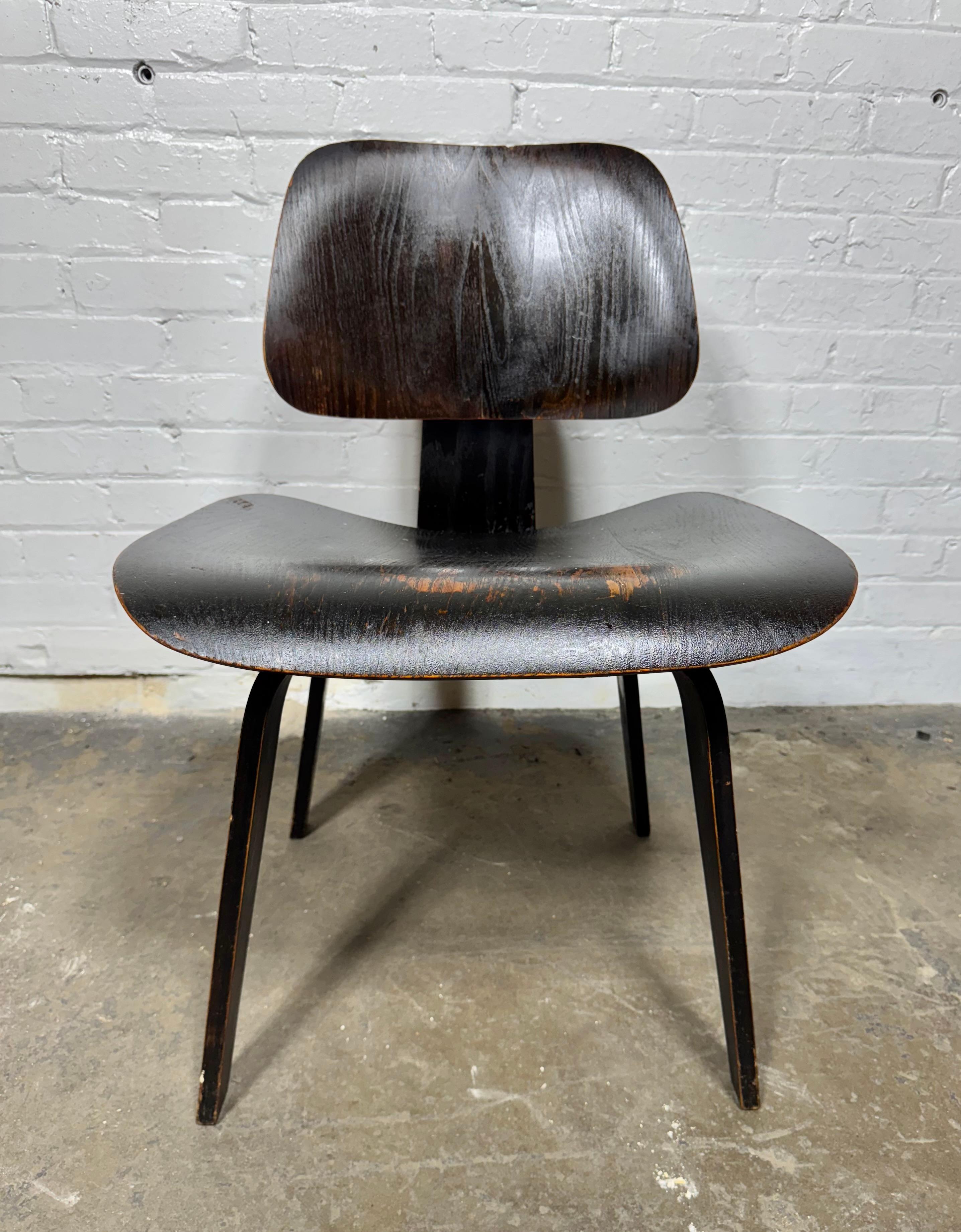 Rara silla Herman Miller DCW de finales de la década de 1940 con la escurridiza etiqueta Evans Products. Parece tener su tinte original de anilina negra.. desgastado en varias zonas,, 

Una auténtica pieza de coleccionista de la historia del diseño