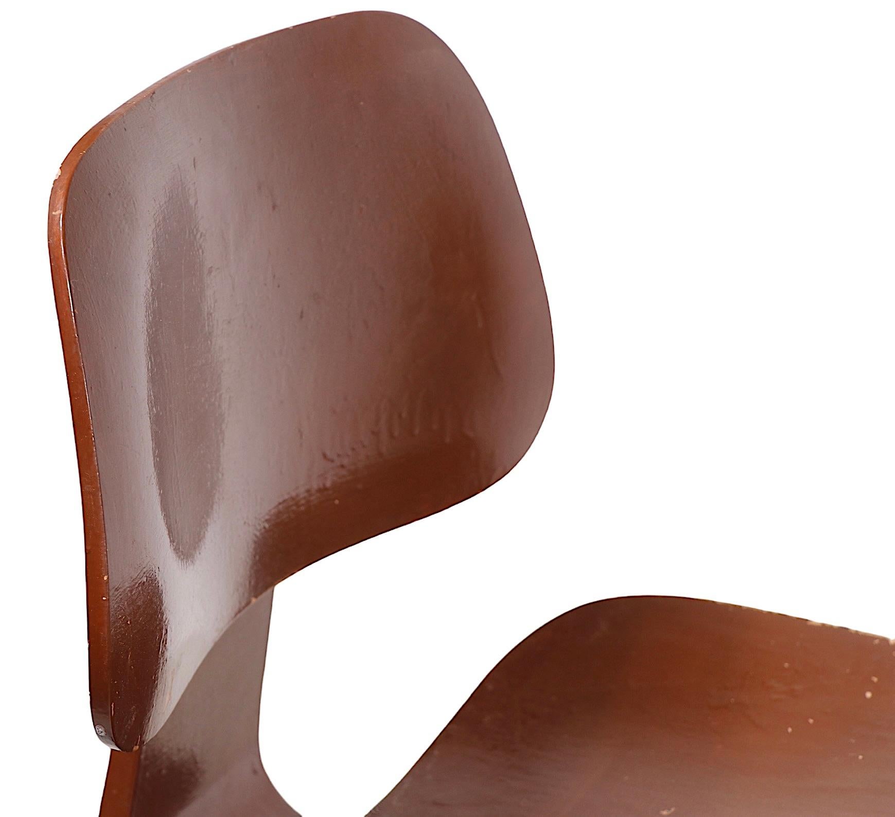  Early example of the classic Eames DCW, having the large oval rubber bumper which is attached to the backrest. This example is structurally sound and sturdy, it has been painted brown, as shown. Usable as is or you could have it stripped and