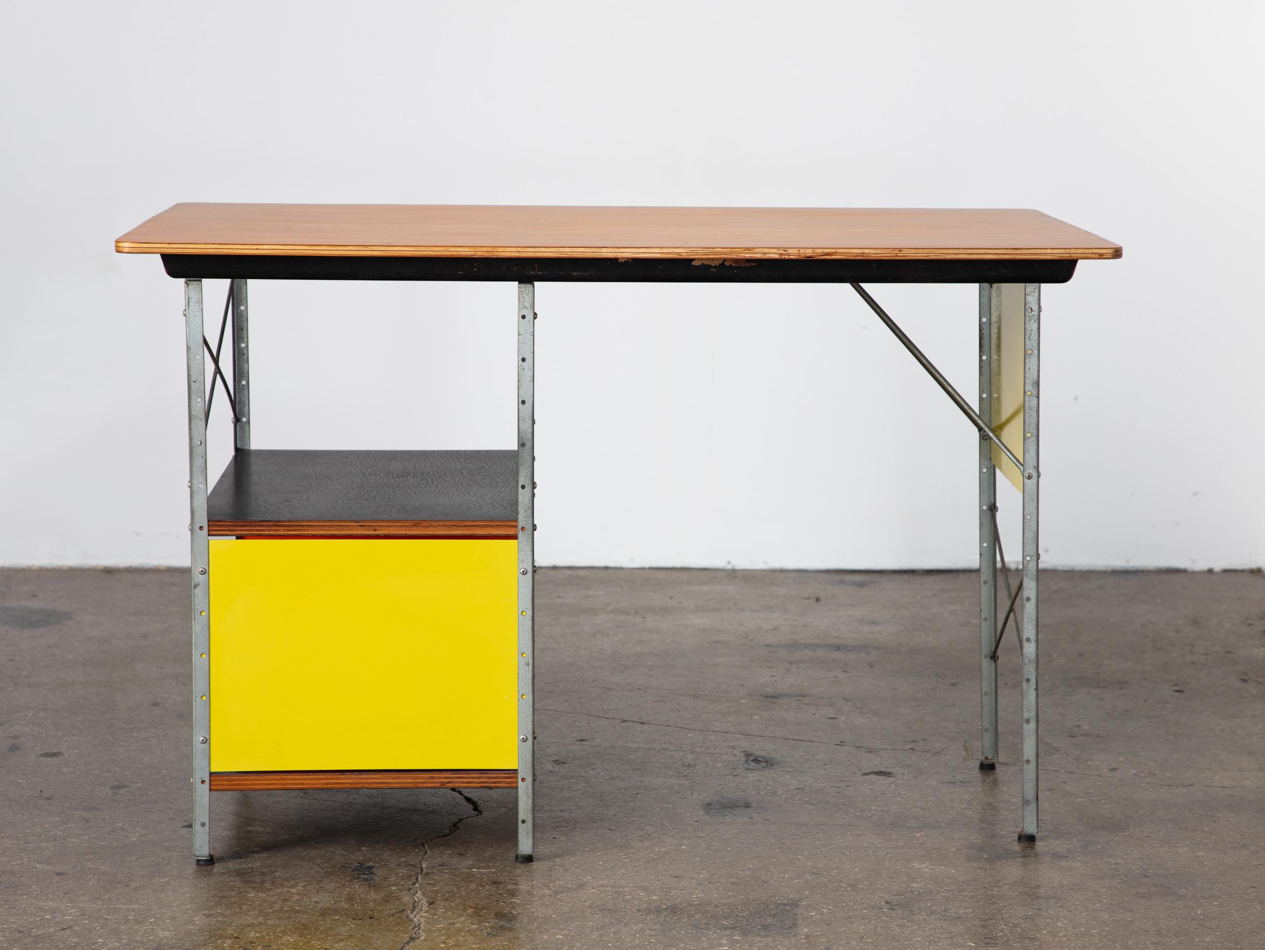 First-generation ESU-D-10-C desk, designed by Charles and Ray Eames, produced by Herman Miller. A rare early production example, distinguished by lacquered Masonite panels in vivid primary colors—red, blue, and yellow. This example features the