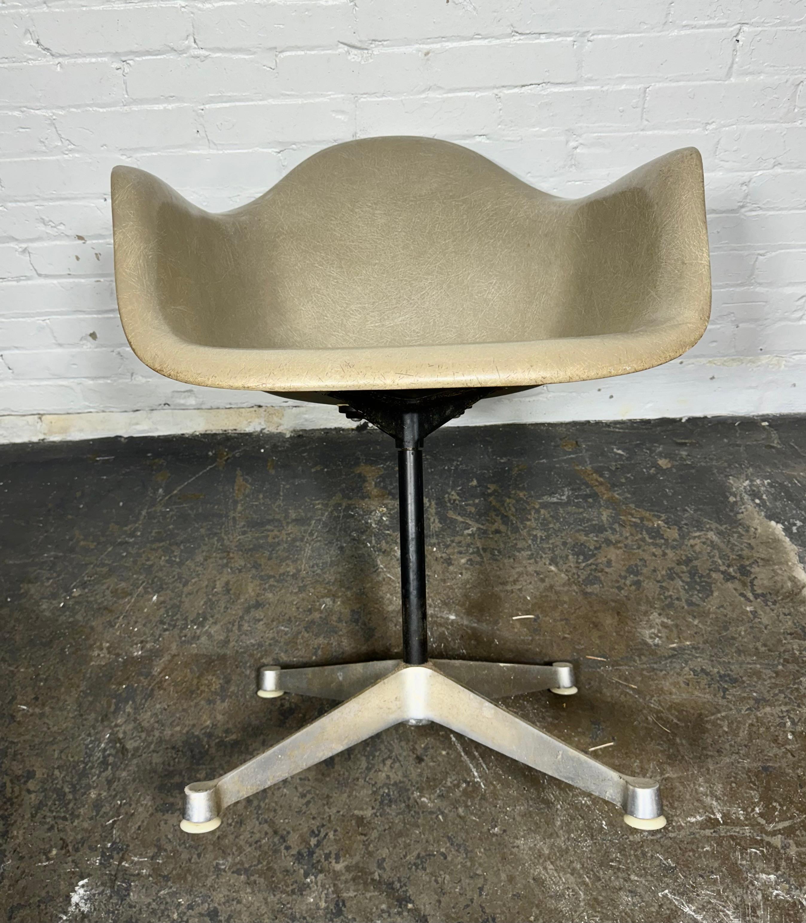 Iconic vintage Eames PAC, pivoting armchair on cast aluminum base, with seldom seen greige color swivel fiberglass shell. It is in wonderful vintage original condition 
Dimensions: Height: 31.75 in (80.65 cm)Width: 25 in (63.5 cm)Depth: 22.5 in