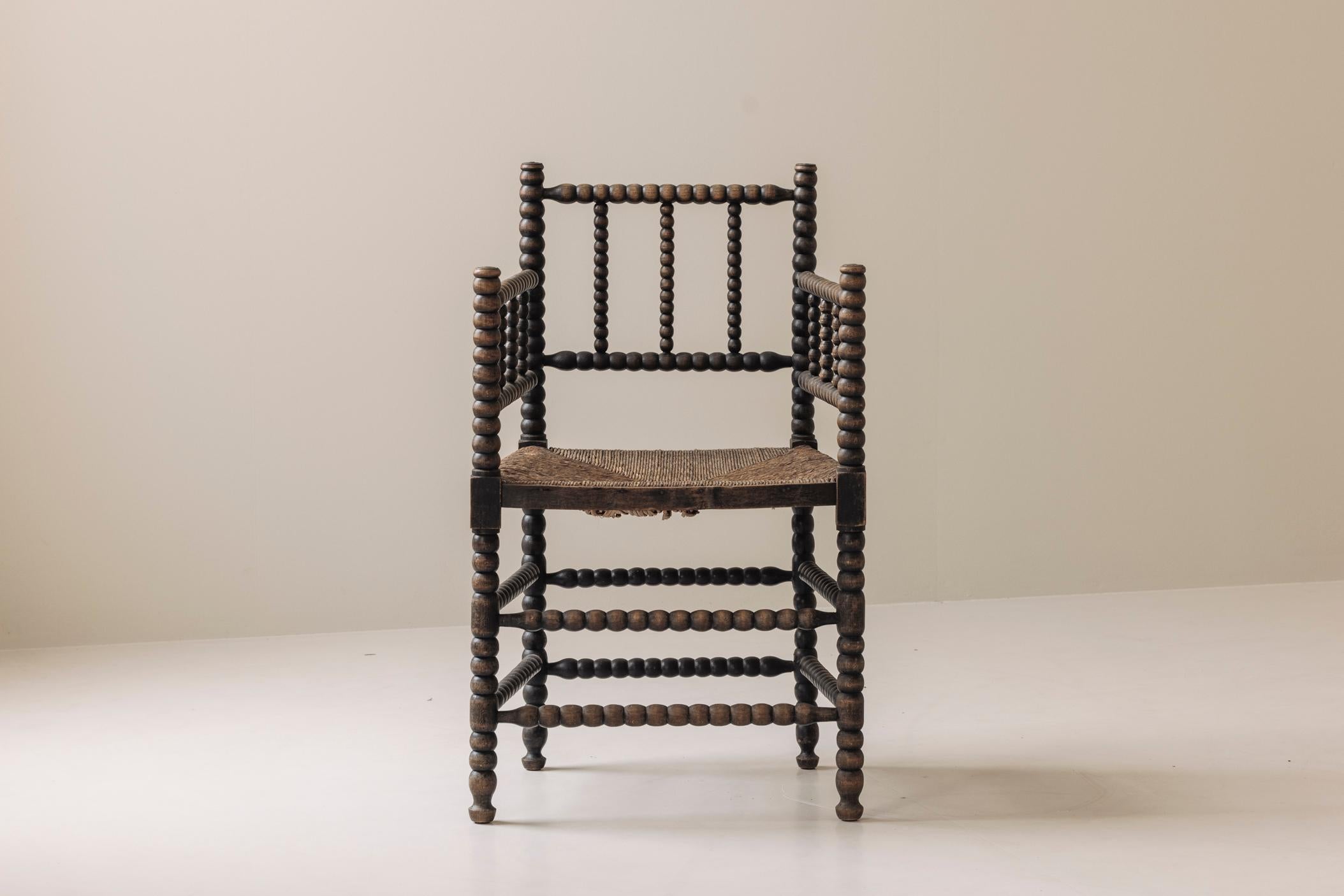 Une exceptionnelle chaise Bobbin de première édition, provenant de France et datant des années 1930. Cette charmante pièce met en valeur les pieds et les brancards tournés aux fuseaux, marque de fabrique de l'artisanat traditionnel qui donne du