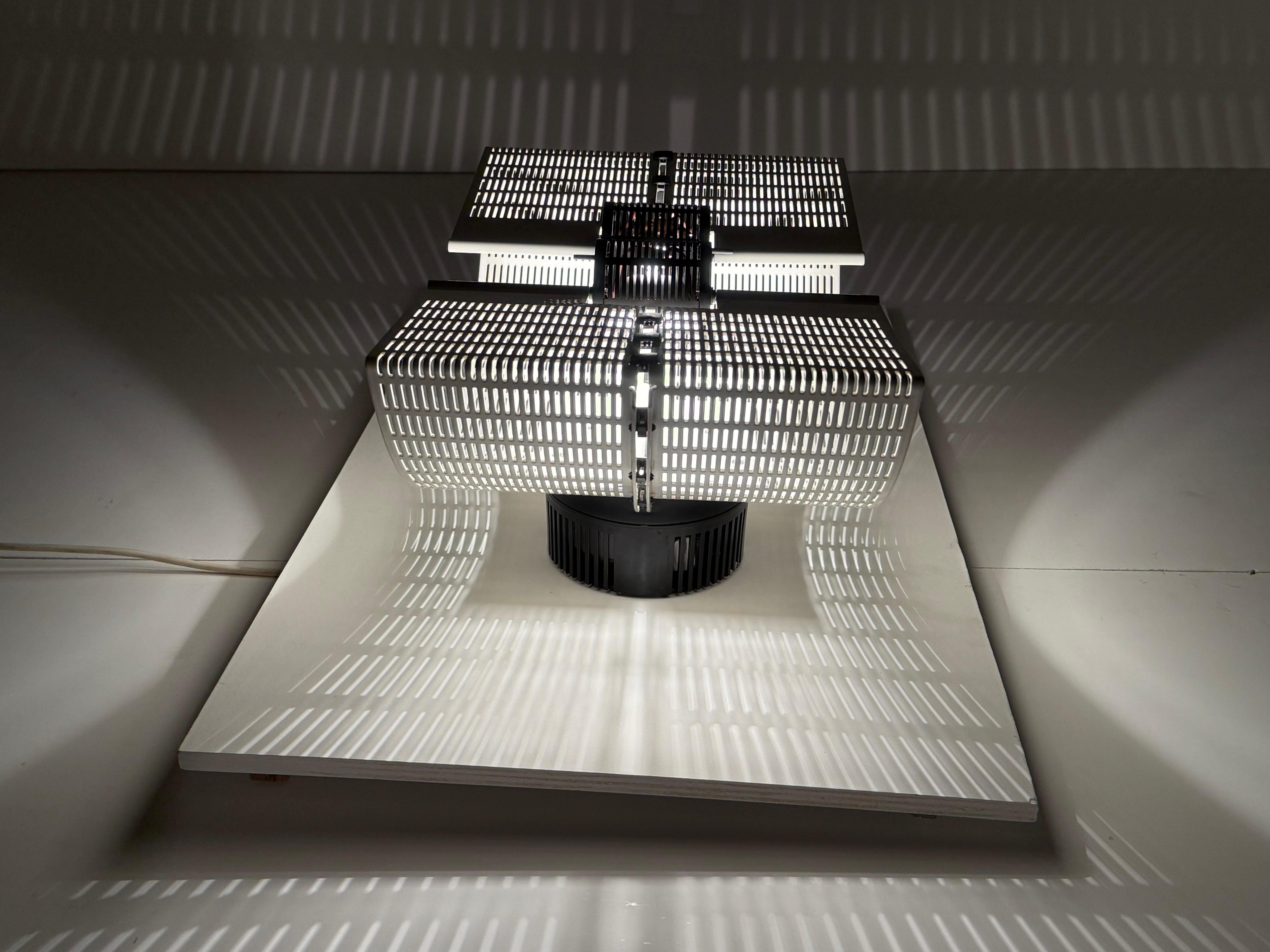 

The simple geometry found in Mario Botta’s buildings is also reflected in this lamp — Fidia, designed by Botta for Artemide in 1986 as a wall lamp features a clear, reduced geometric assemblage of perforated metal plates showing beautiful light