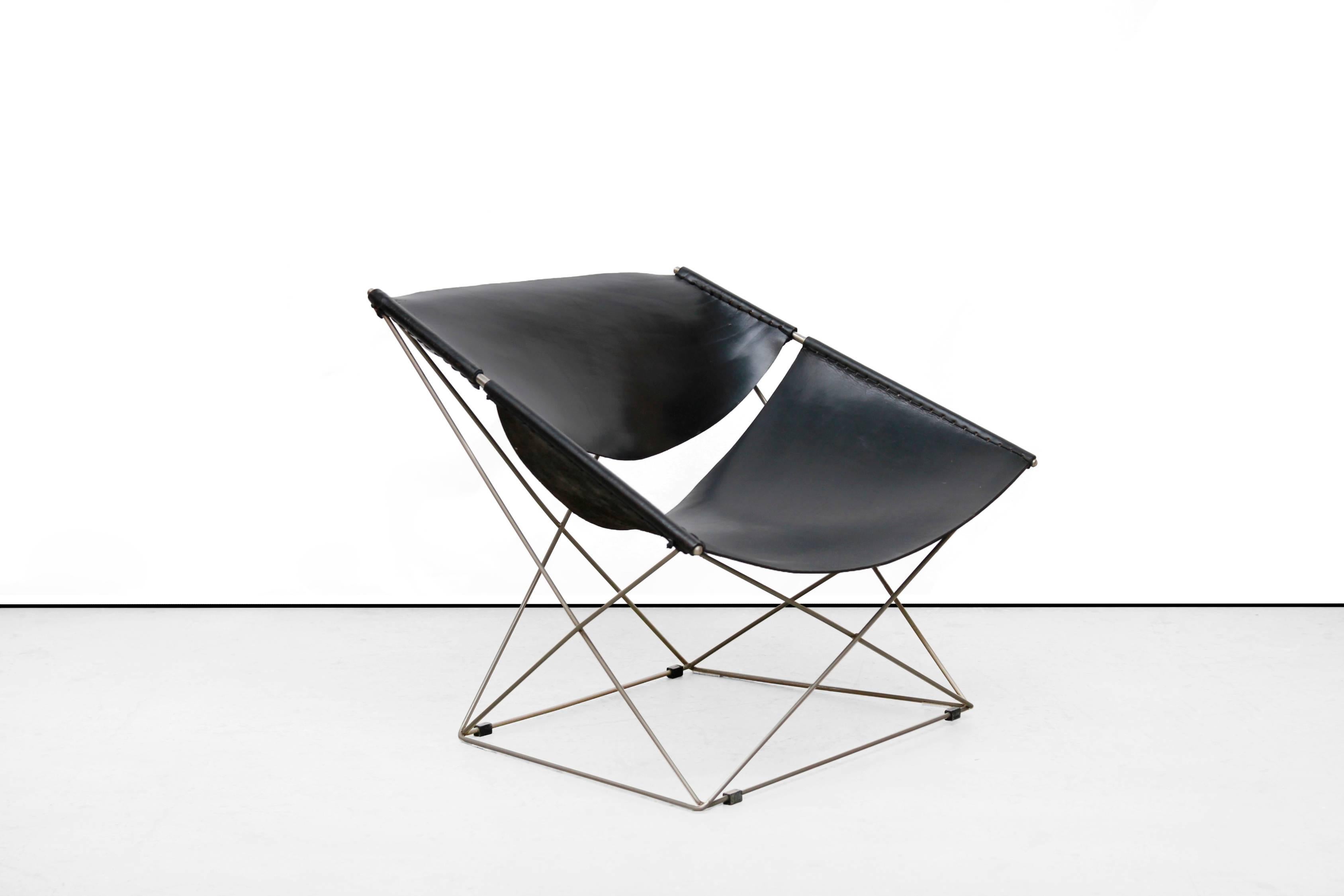 This Minimalist black leather armchair was designed by French top designer Pierre Paulin for Artifort, The Netherlands in 1963. This chair, type F675, is better known as the butterfly chair by Pierre Paulin. This model is an original early edition