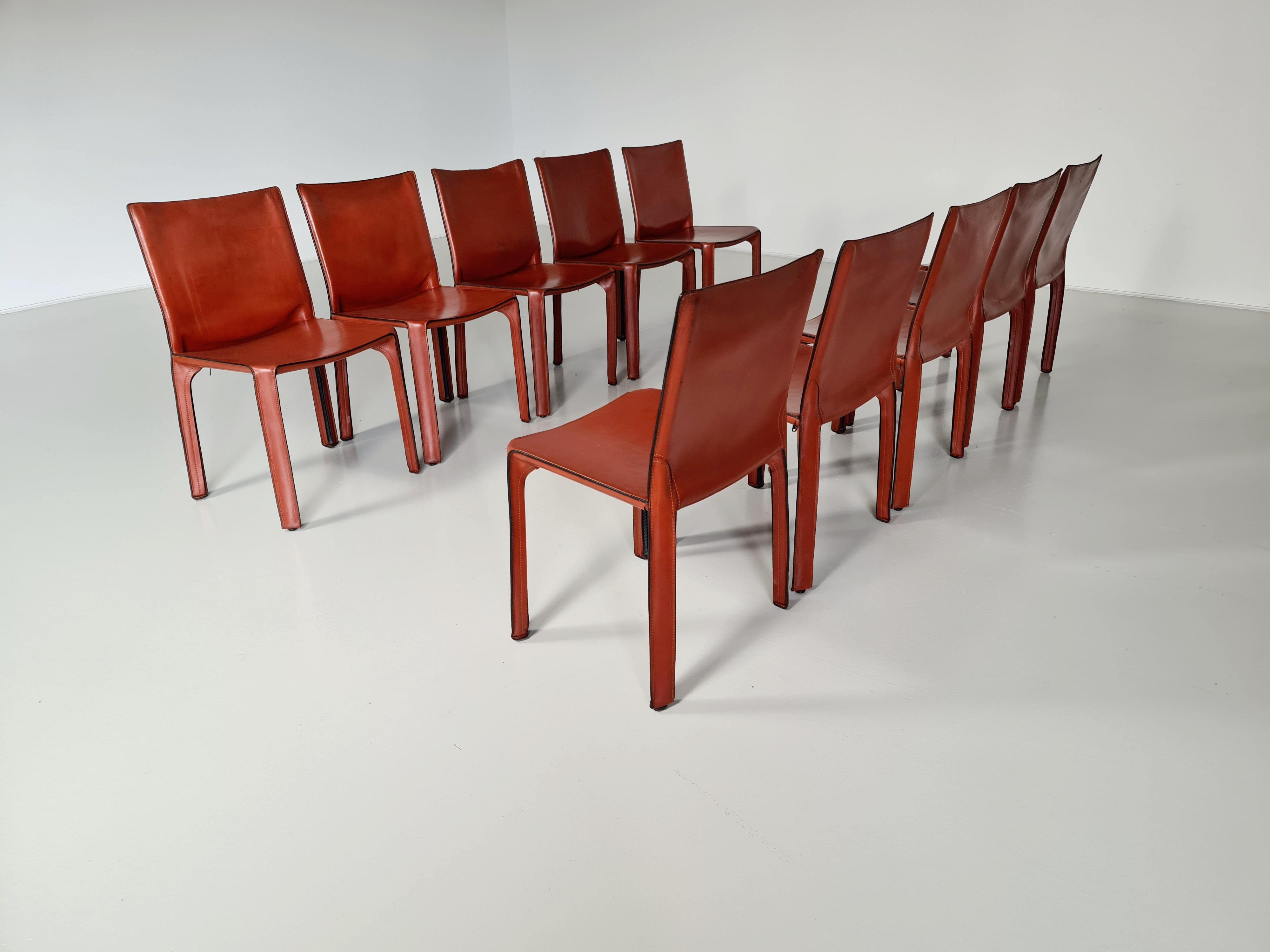 Set of 10 CAB-412 dining room chairs in Russian Red (also known as Bulgarian Red) saddle leather. Designed by Mario Bellini and manufactured by Cassina in the 1970s in Italy. These chairs are the early edition. The leather cover is stretched over a