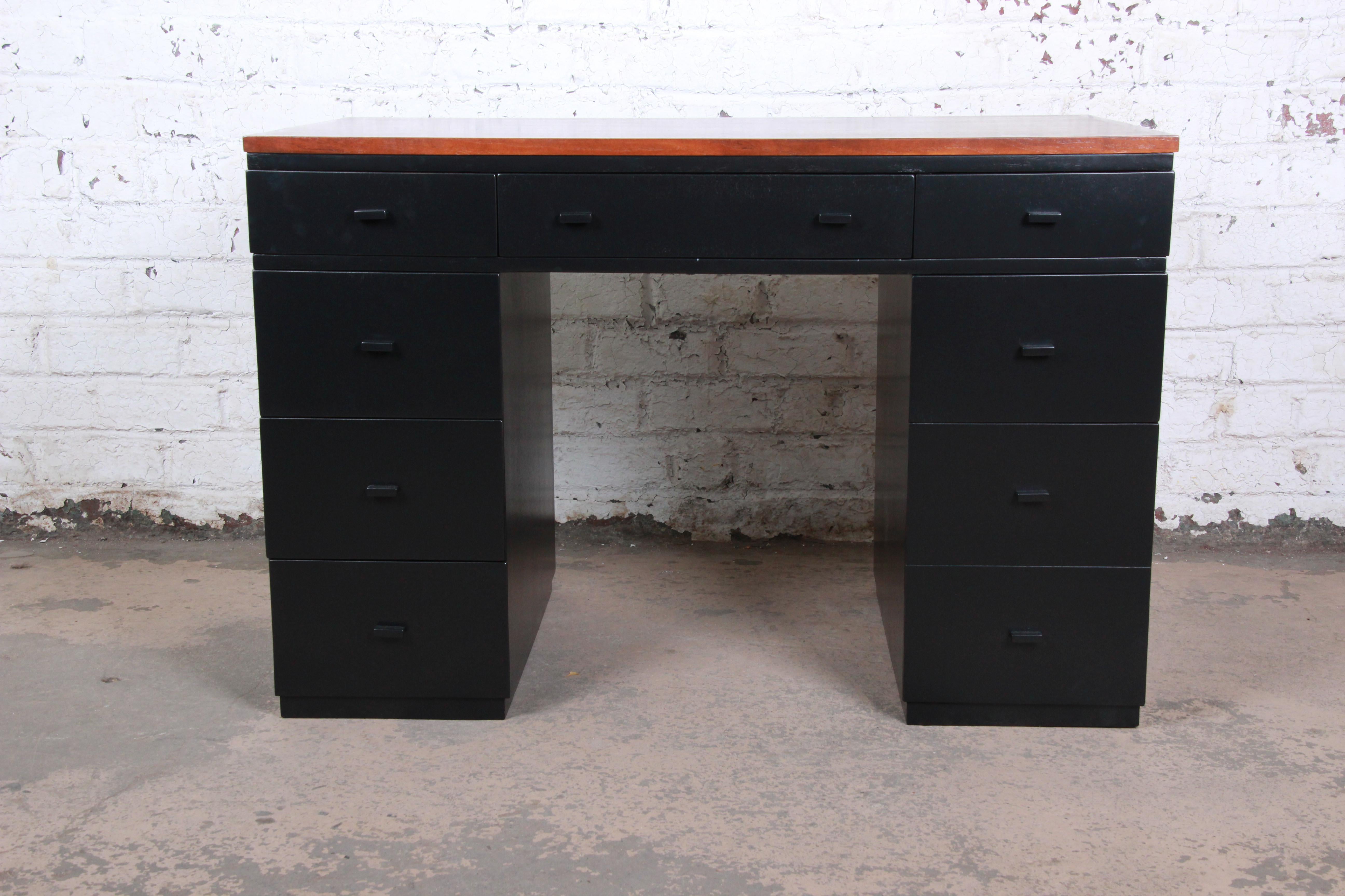 An exceptional newly restored kneehole desk by Edward Wormley for Dunbar Furniture. This is a rare surviving piece of Wormley's early Dunbar designs, circa 1941. The desk features a sleek black lacquered finish, with a stunning walnut top. It offers