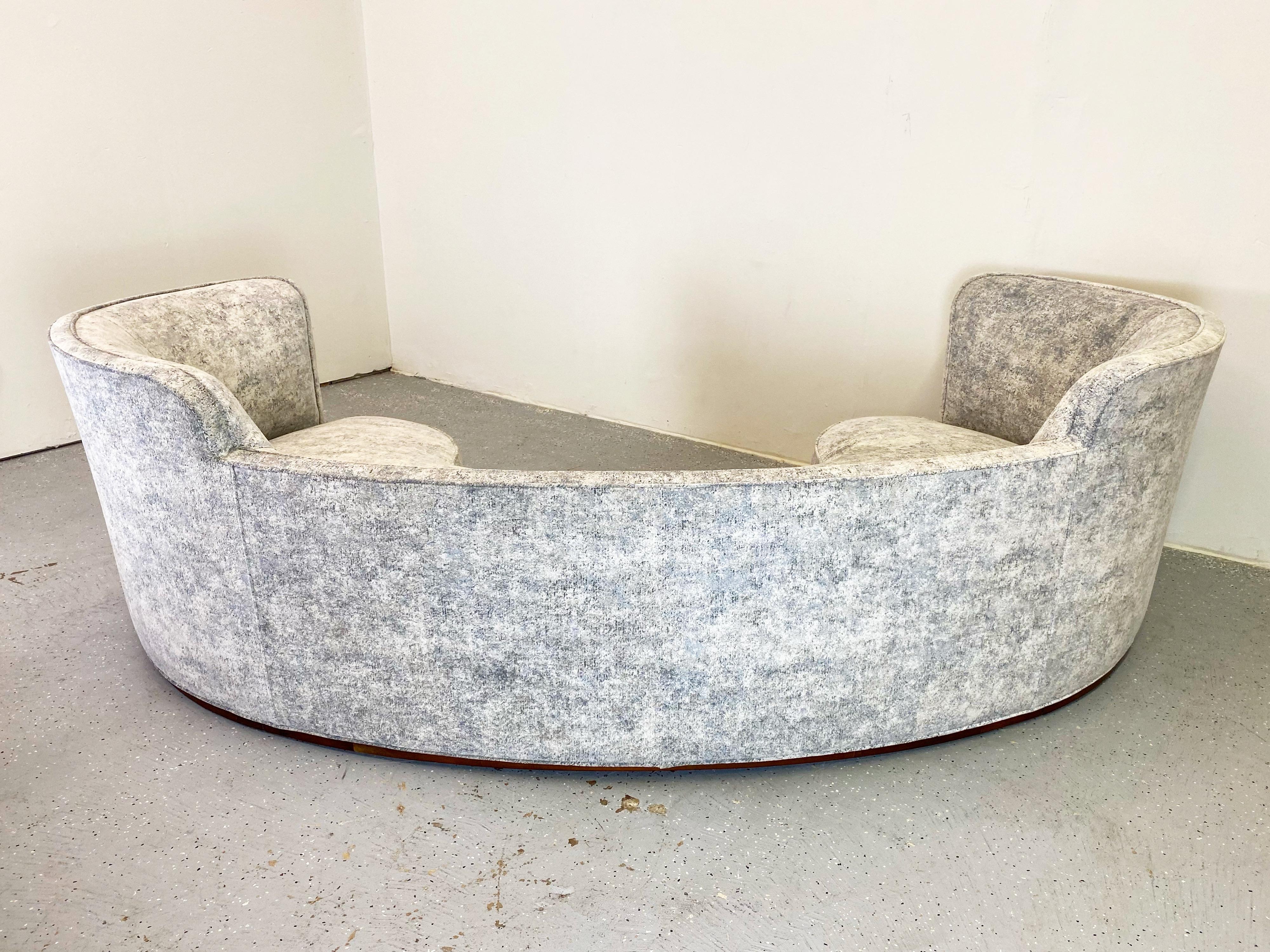 This sofa is an excellent example of modern elegance. An extraordinary substantial piece fully restored and sitting lightly on a recessed walnut base. The new upholstery is soft and sturdy and shows a beautiful blend of light blue, grey, and white.