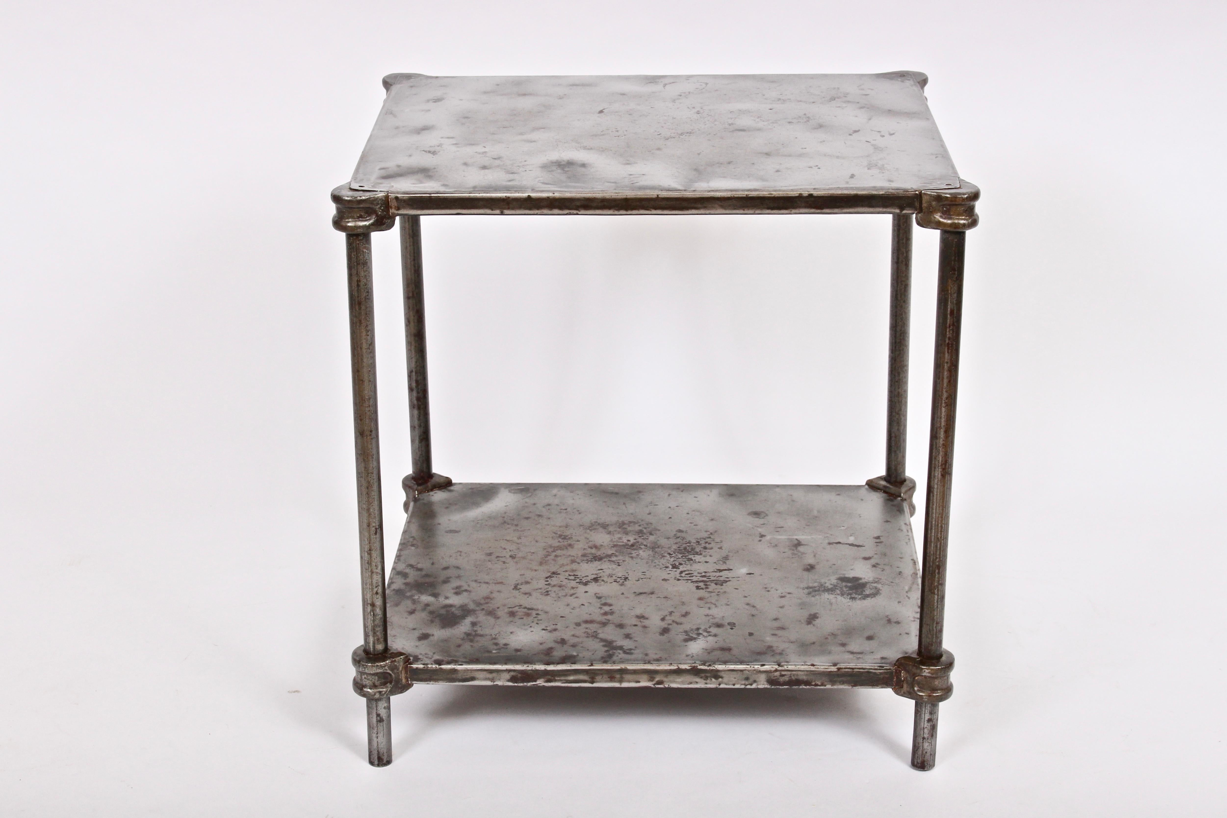 Industrial iron two shelf factory table, single nightstand, end table, tv stand, circa 1900. Featuring a rectangular form with two levels of Iron sheet metal, Iron rods, Iron pipe, corner castings and pinned corner detail. Bottom Shelf 4H from
