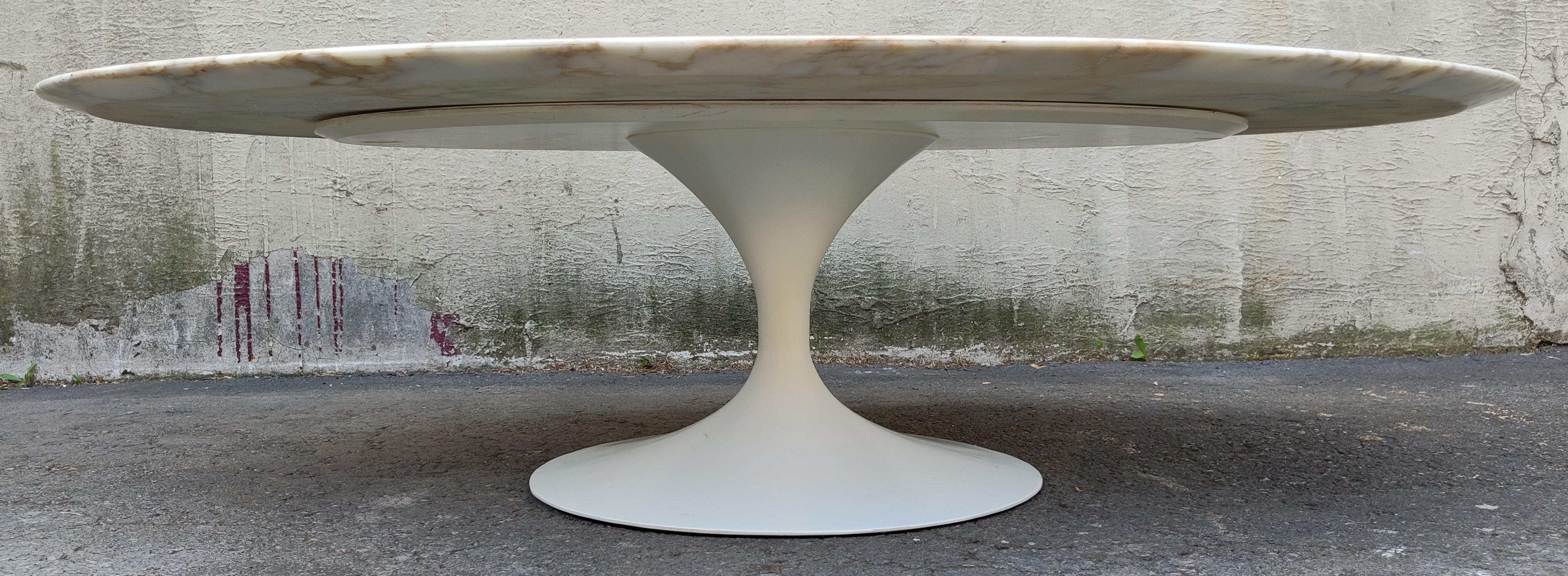 Originally designed by Eero Saarinen, this table was manufactured in the 1960s by Knoll International for resale in the heart of New York City. Being an early model, this specification is rare for its time, a white enameled cast-iron base and the