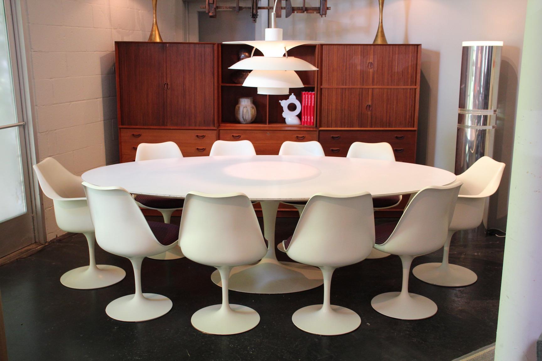 An early and large dining set designed by Eero Saarinen for Knoll. Set consists of an eight foot table and ten swivel chairs.