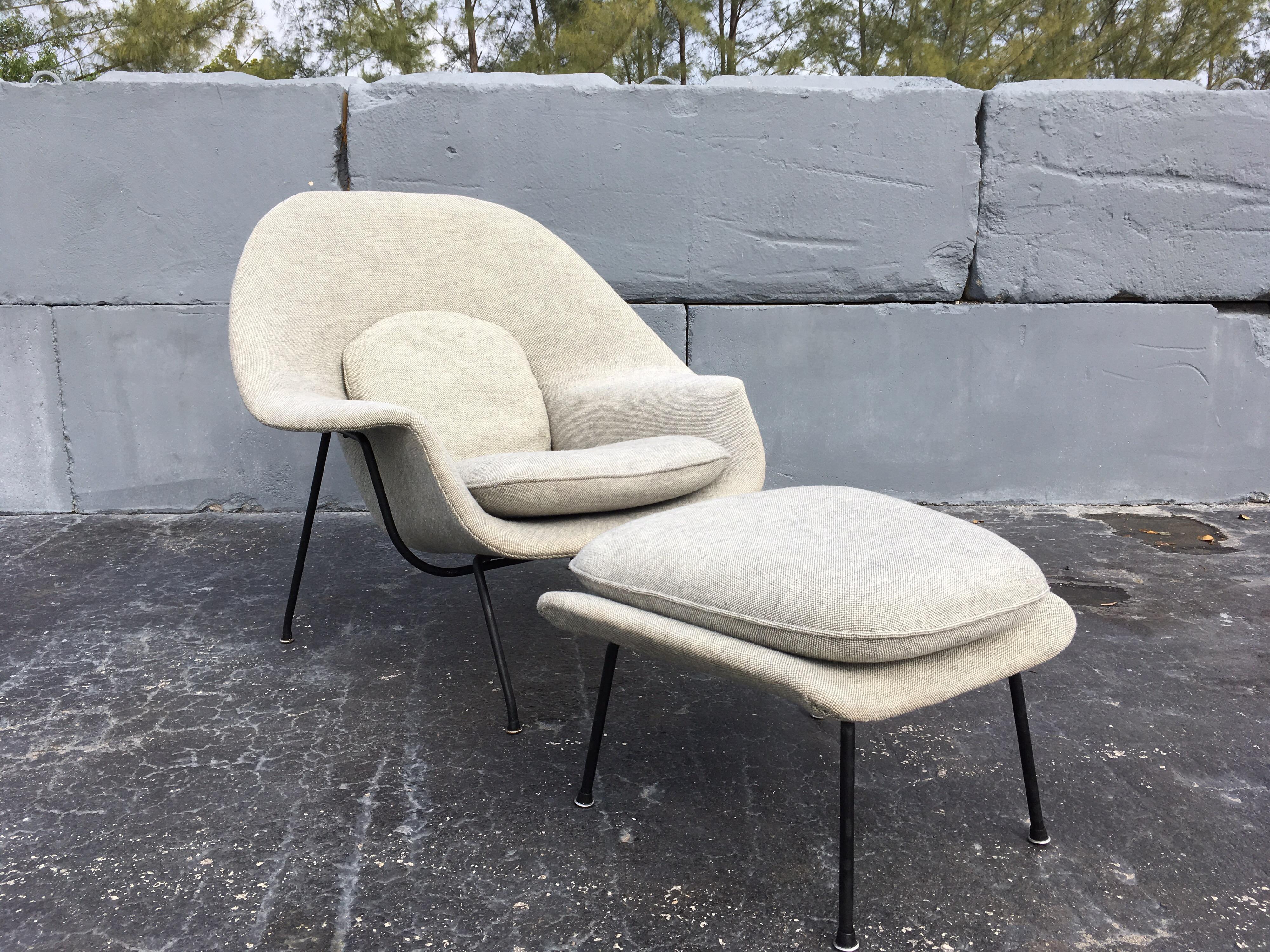Early example, 'Womb' chair and ottoman by Saarinen for Knoll. We believe the fabric is original. Fabric and foam are in good condition for the age. Iron frame retains its original black paint and press-on glides. 
There is some normal paint loss