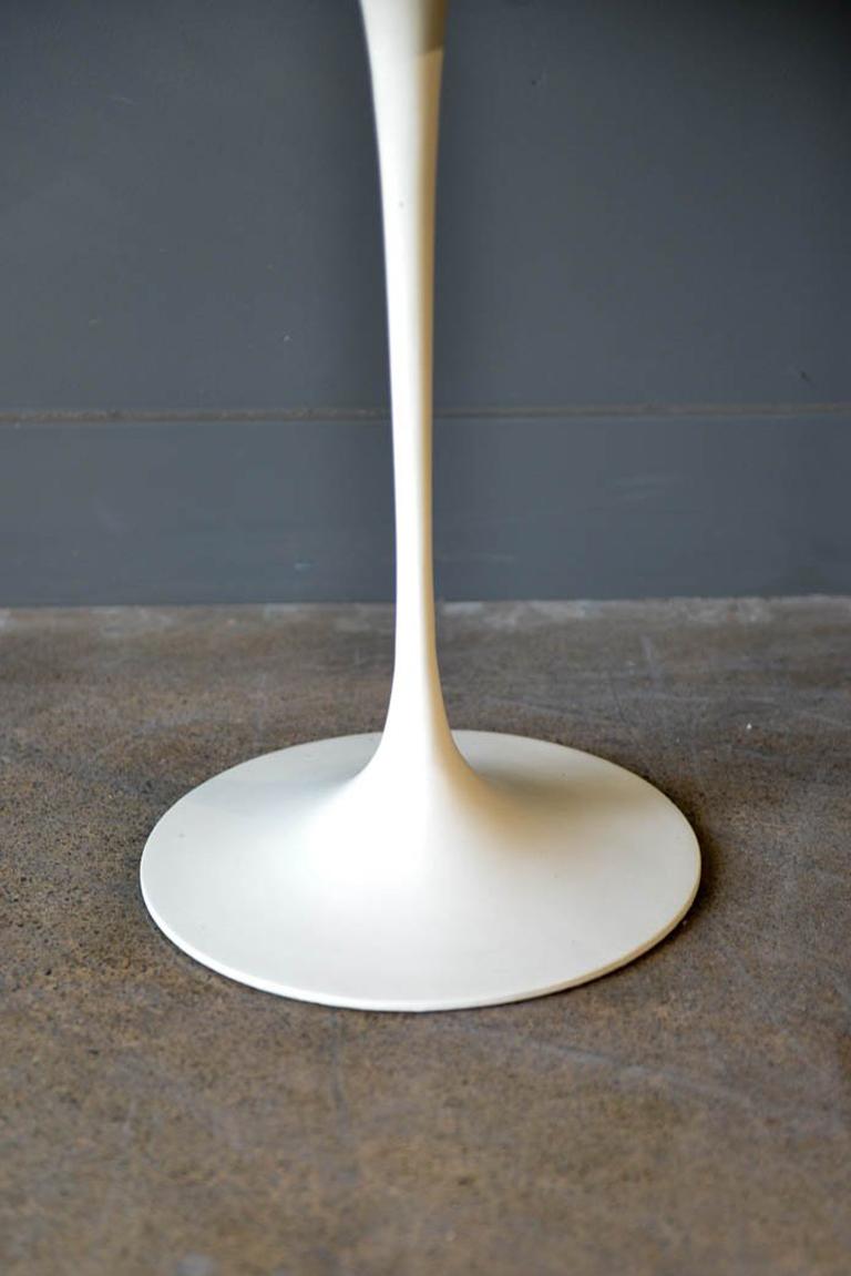 Early Eero Saarinen Tulip side table for Knoll, circa 1960. Early solid cast iron base, white laminate top. Some wear to edges as shown, but top and base are very good condition. Measures: 20.5