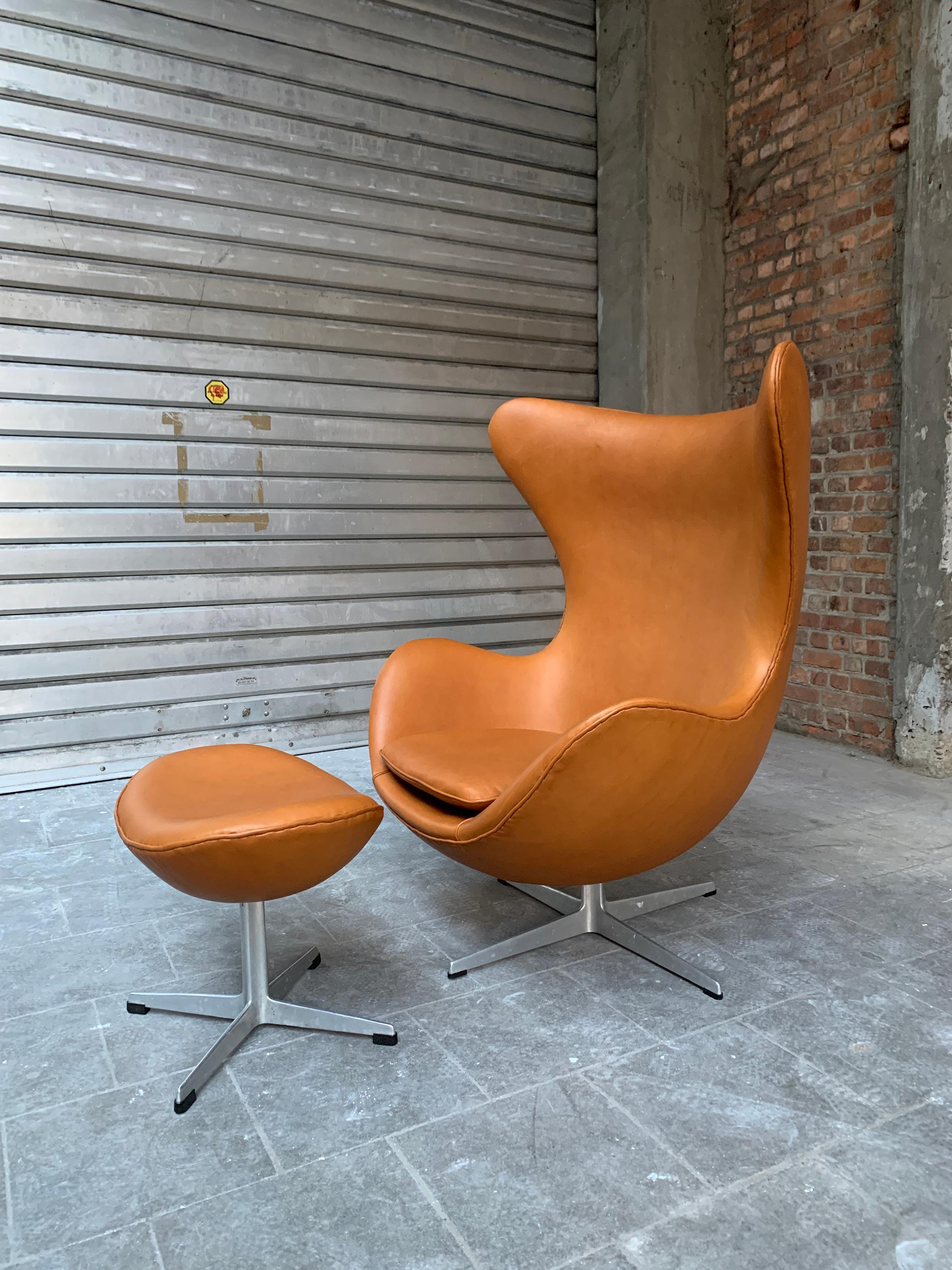 An absolute design-icon, the Egg chair by Arne Jacobsen with it’s footstool produced in 1966. 

Newly reupholstered in European Nappa leather by using the original techniques. This means manual stitching of the leather piping all around the chair