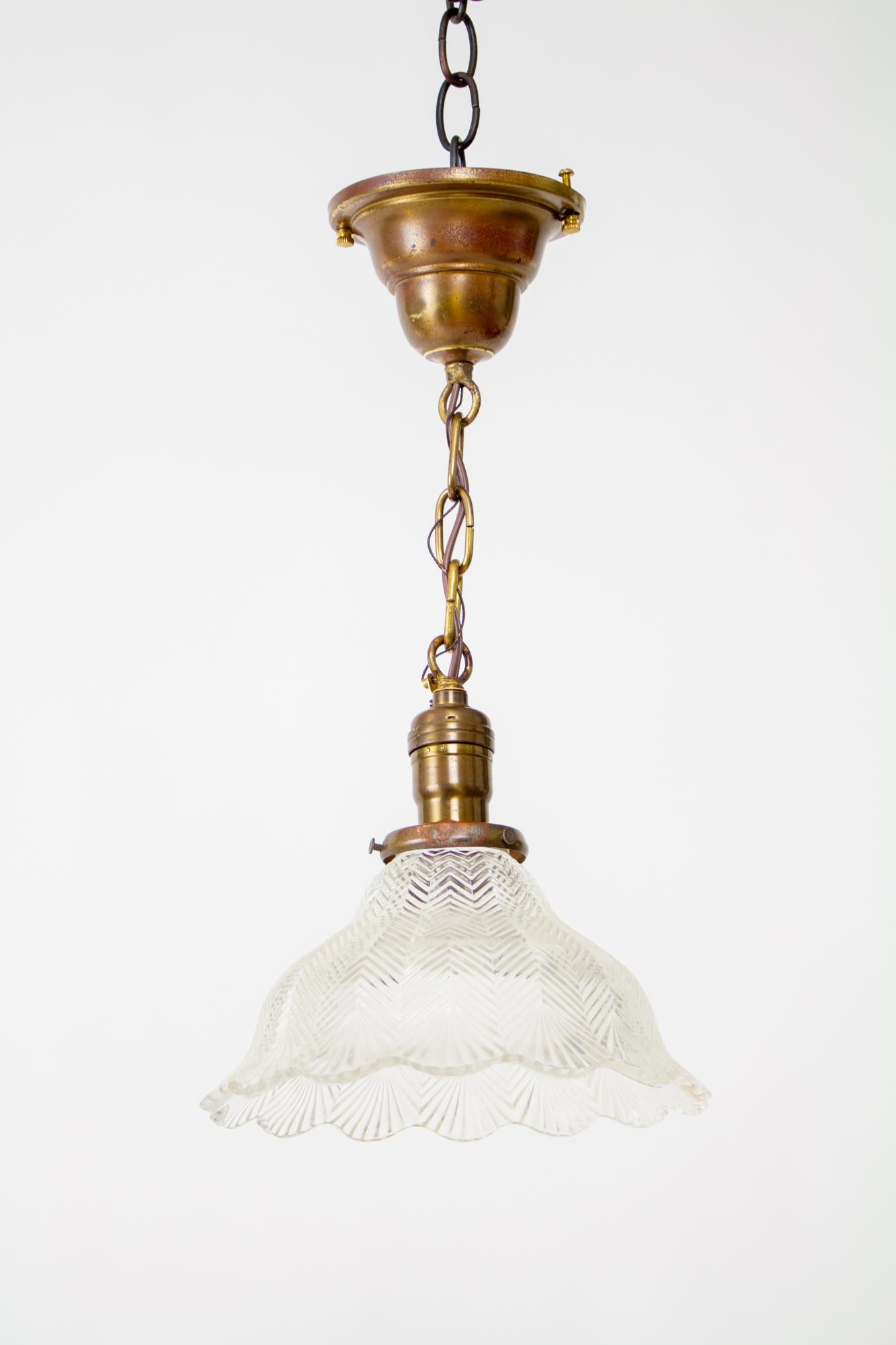 Early Electric Prismatic Hanging Pendant. A simple chain fixture with canopy and bell shaped shareholder. Clear prismatic glass shade in a bell shape with ruffled edges. A classic fixture that would be wonderful for an informal traditional space