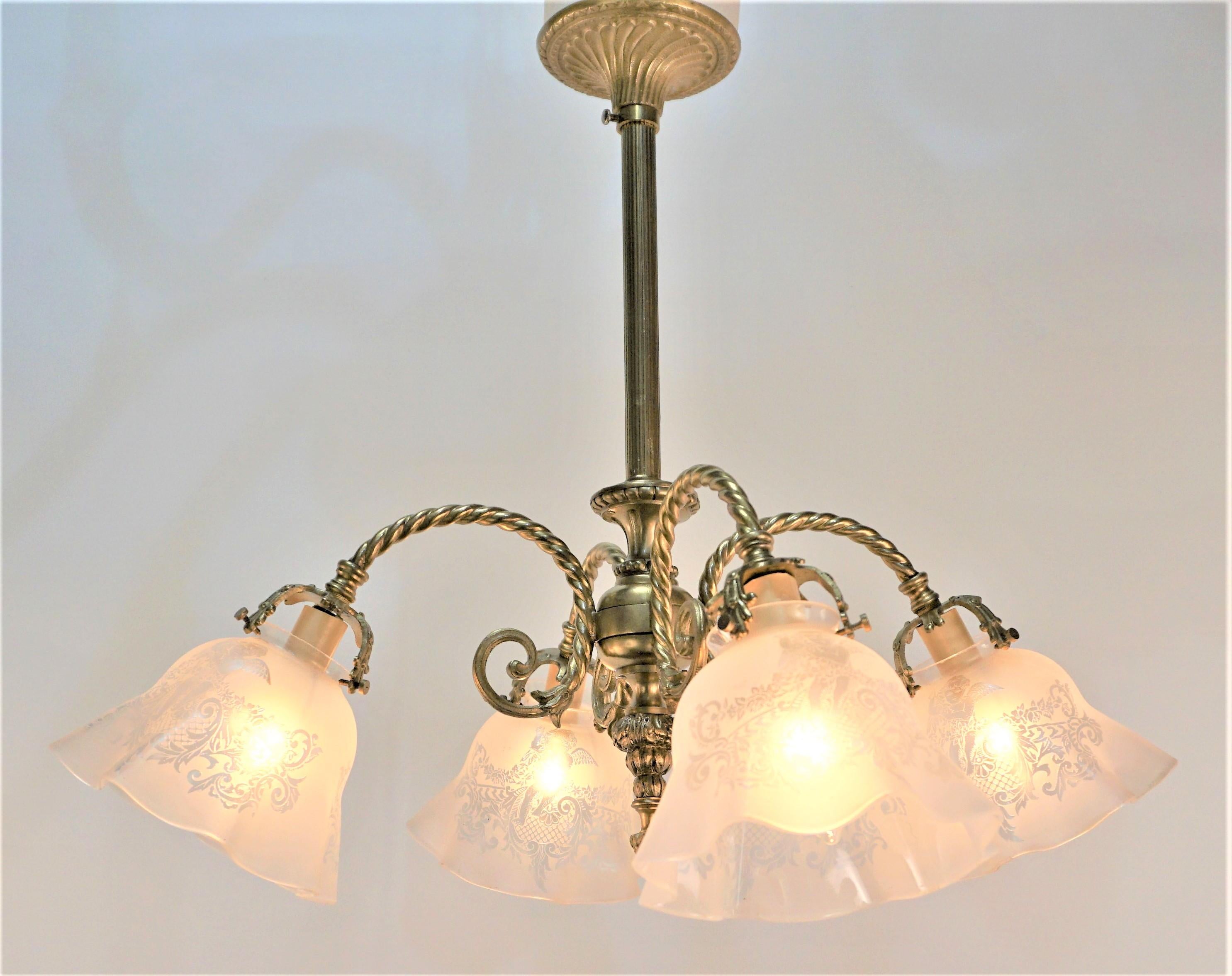 Early electrical four arm bronze chandelier with etched cherub glass shades.
Width 21