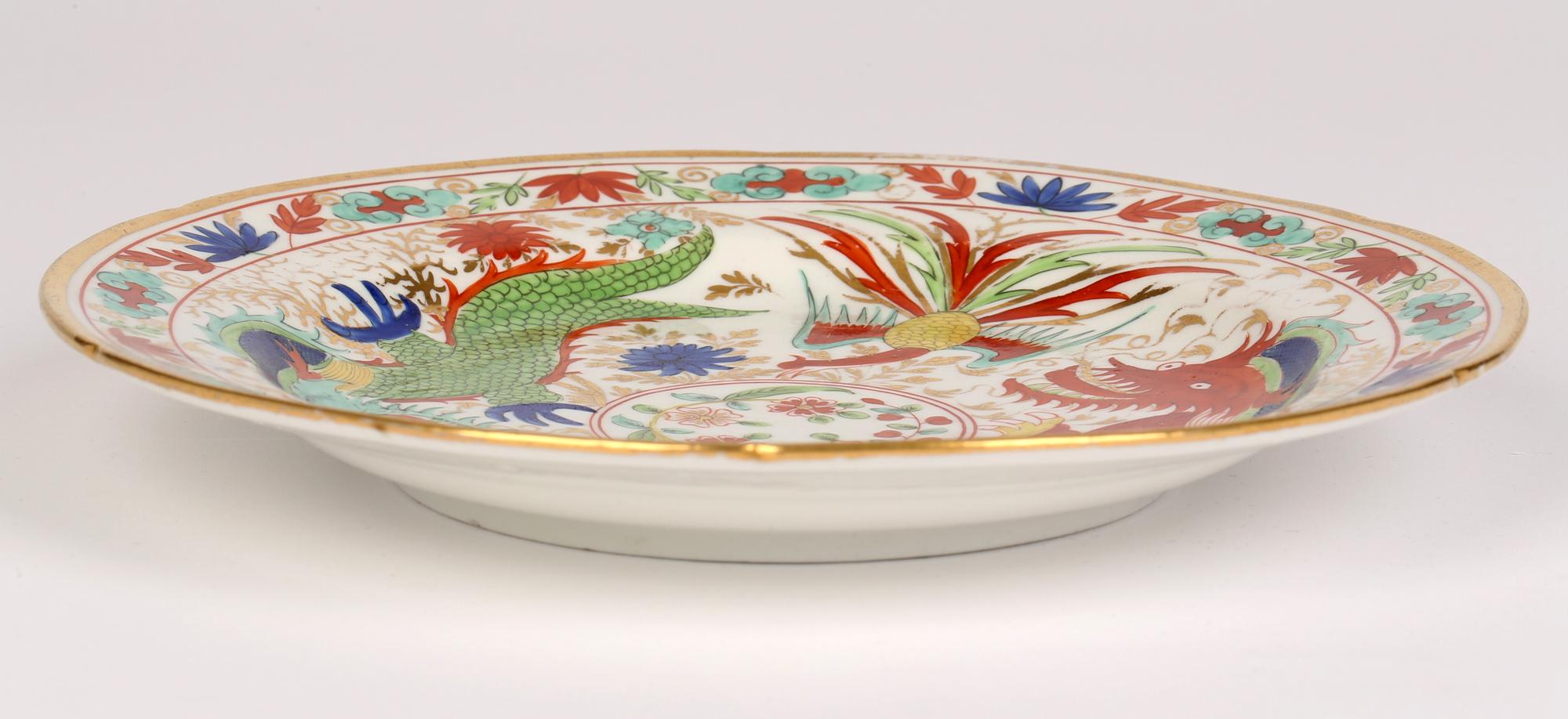 A rare and early English porcelain cabinet plate hand painted with Chinese dragons and phoenix birds and probably inspired by Chinese porcelain believed to date from the early 19th century. The plate has a raised edge with a shaped rim and is hand