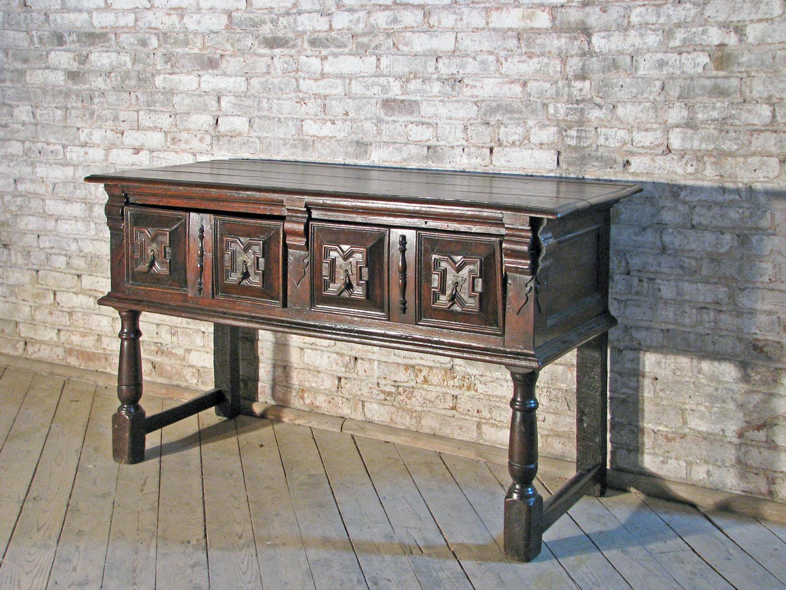 English Jacobean / Charles II, mid 17th Century sideboard or dresser of rare, small size, robust construction and beautiful detailing. The molded edge top above two drawers with geometrically molded drawer fronts and brass pulls, supported by turned