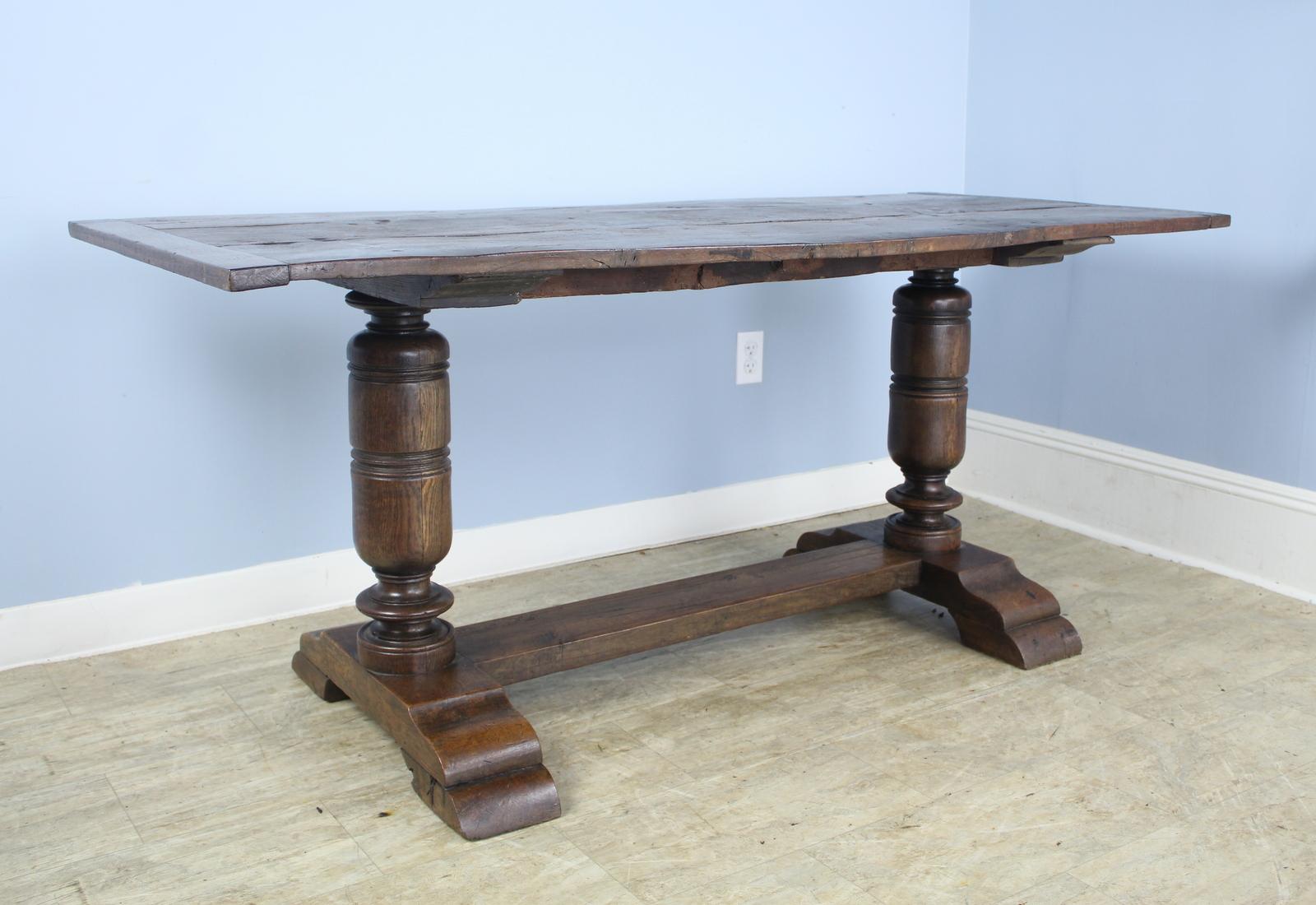An English oak tavern table, circa 1700. The eye is immediately drawn to the dramatic turned legs and carved feet. The top, fashioned of three planks with breadboard ends, is appropriately distressed for it's age. We considered trying to correct the