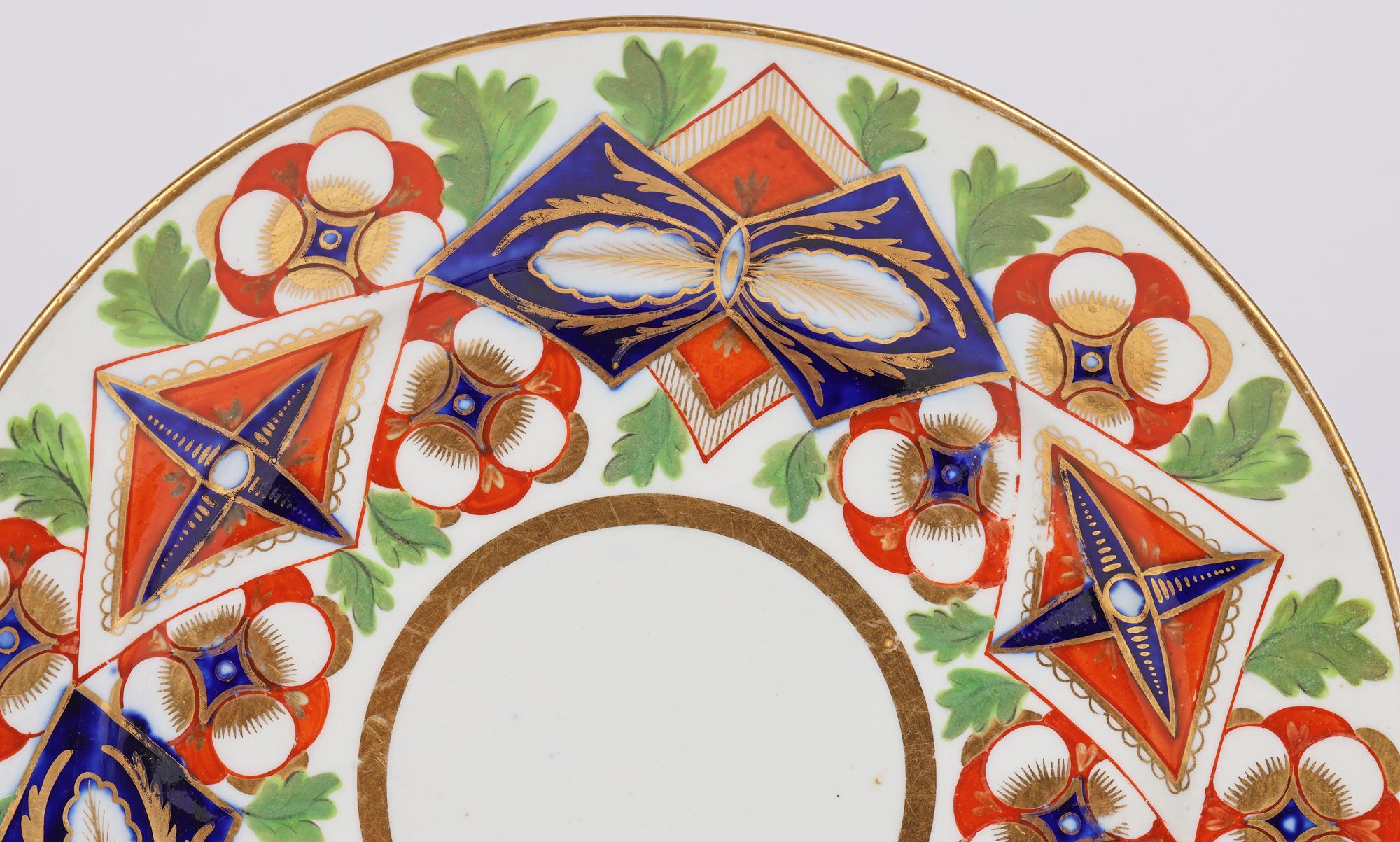 A very stylish and fine pair of early English porcelain plates hand decorated in the Imari style and dating from around 1810. The plates of round shape stand raised on a narrow round foot with a raised edge and recessed centre. Both are hand painted