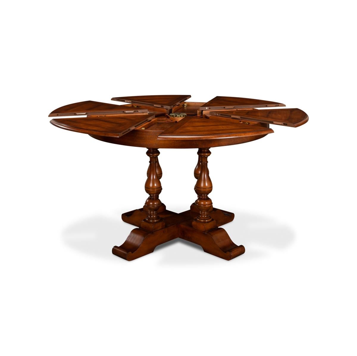 Early English style round extendable jupe dining table extending to 56 inches. Walnut table is veneered in finely figured walnut segments and supported on four solid vase-shaped turned legs leading to the X form base.

The table extends from 45 to
