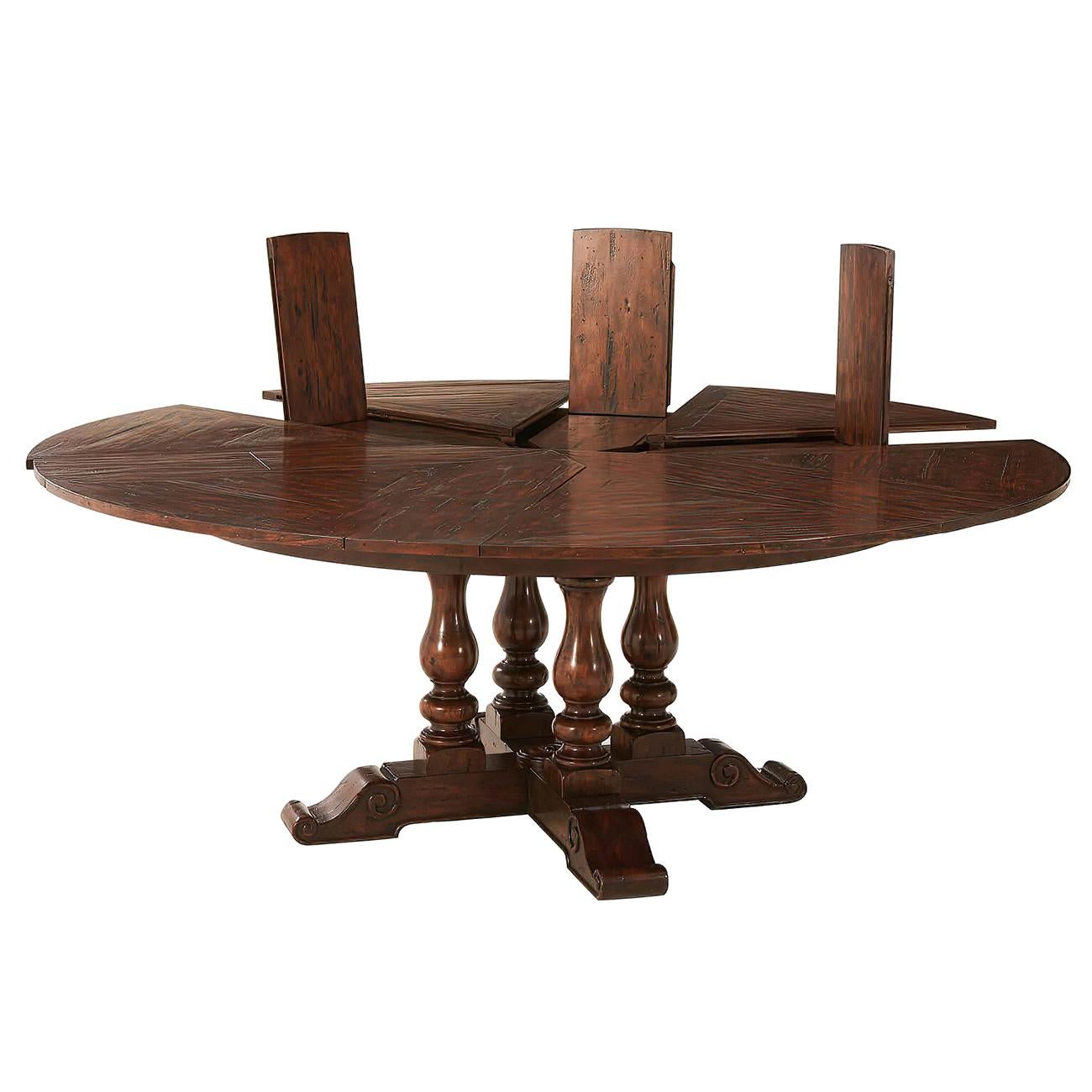 An antiqued wood circular extending dining table, the circular top of parquetry panels with six pull-out sections revealing self-storing fold-out leaves, above four baluster turned supports, on a crossover scroll foot base. The original 17th century