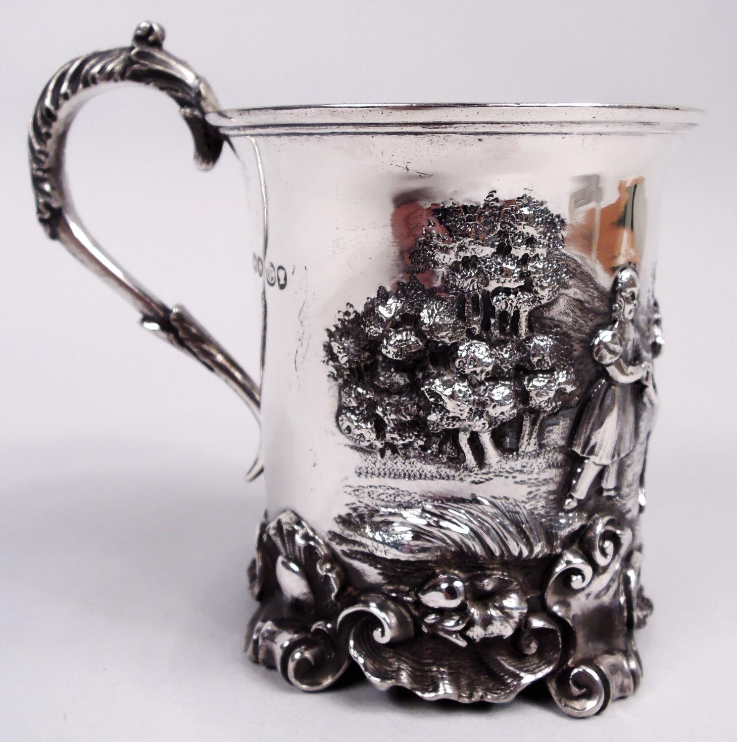 Victorian sterling silver baby cup. Made by George Reily & George Storer in London in 1838. Flared rim, high-looping leaf-capped and -wrapped s-scroll handle, and applied shell and scroll foot. In relief are trees and hills, a child and pony in the