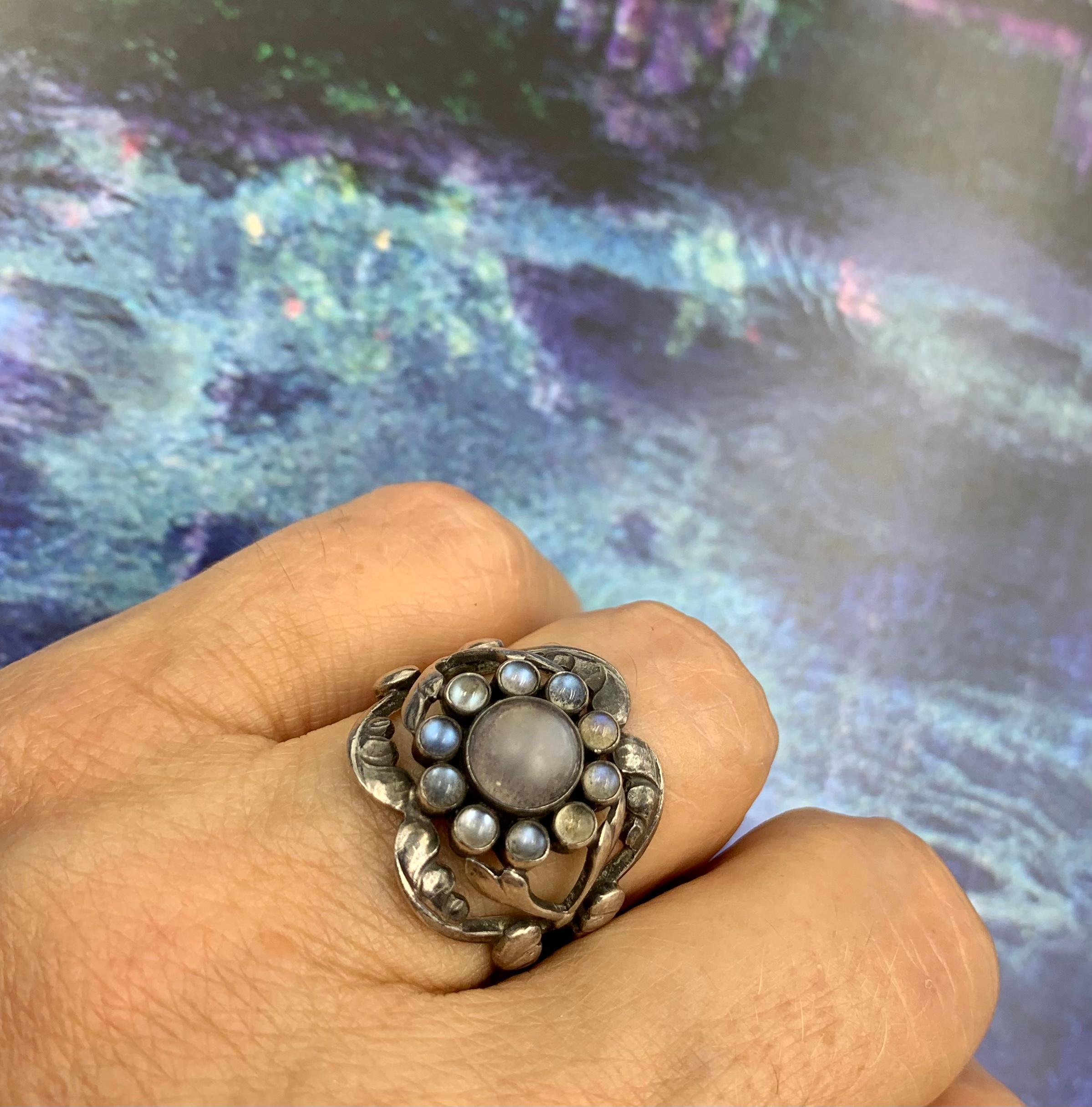 Anillo temprano Georg Jensen, circa 1930, de piedra lunar Moonlight Blossom y plata de ley, diseñado por el propio Georg Jensen. La icónica colección Moonlight Blossom es una de las más admiradas y reconocibles de los diseños de Georg Jensen. De